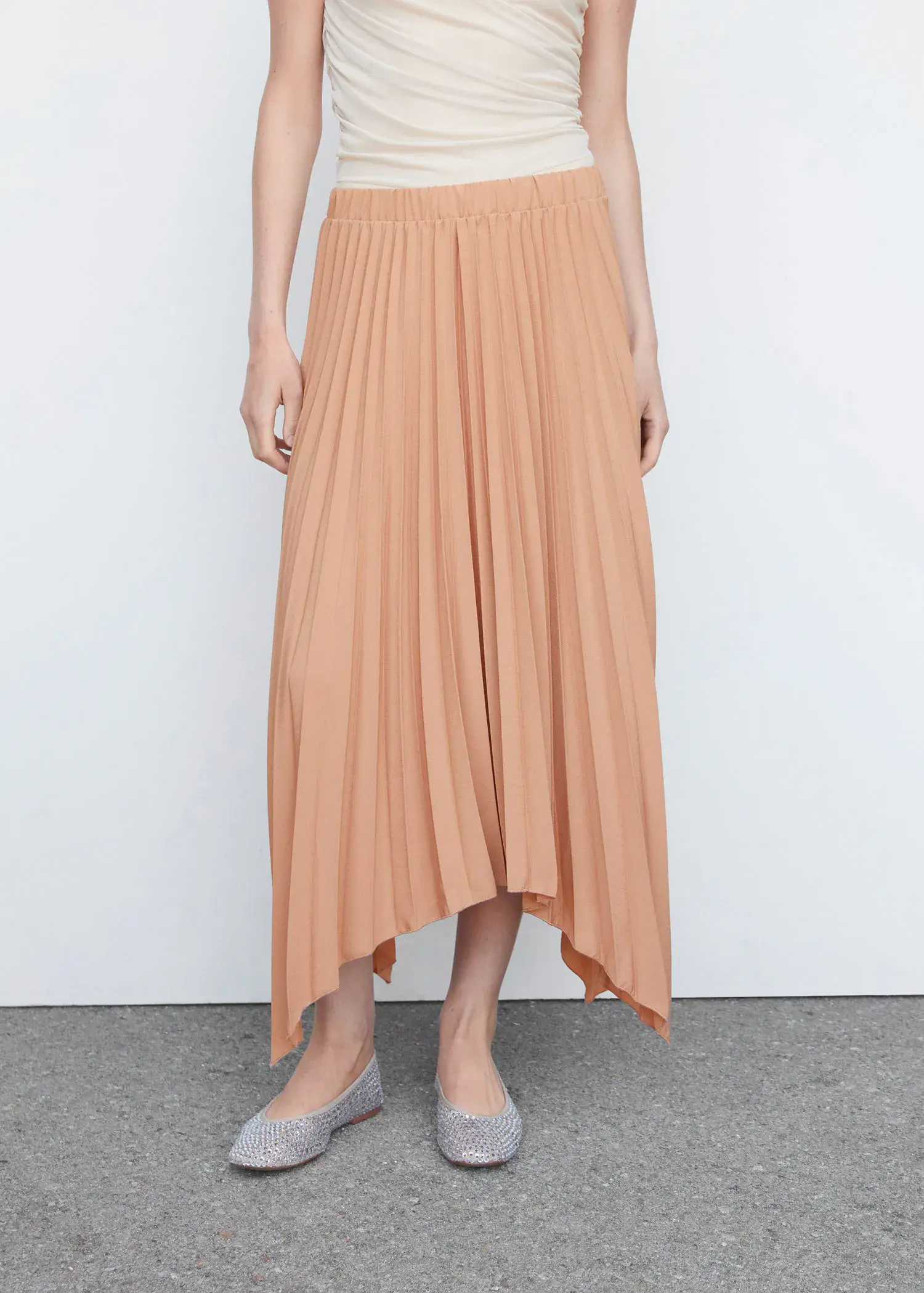 Mango Pleated asymmetric skirt . a person standing in front of a white wall. 