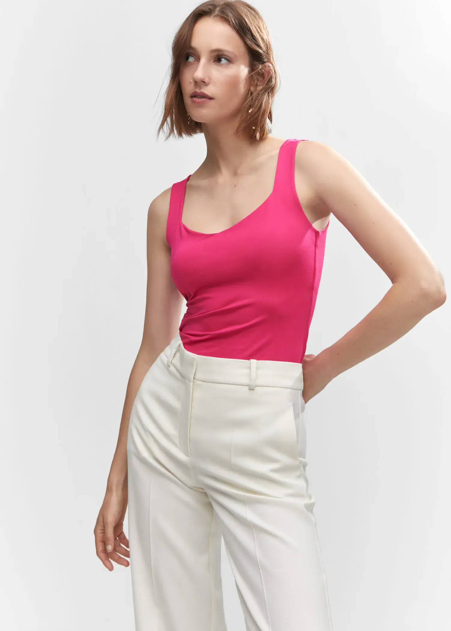 Mango Open elastic top. a woman wearing a pink tank top and white pants. 