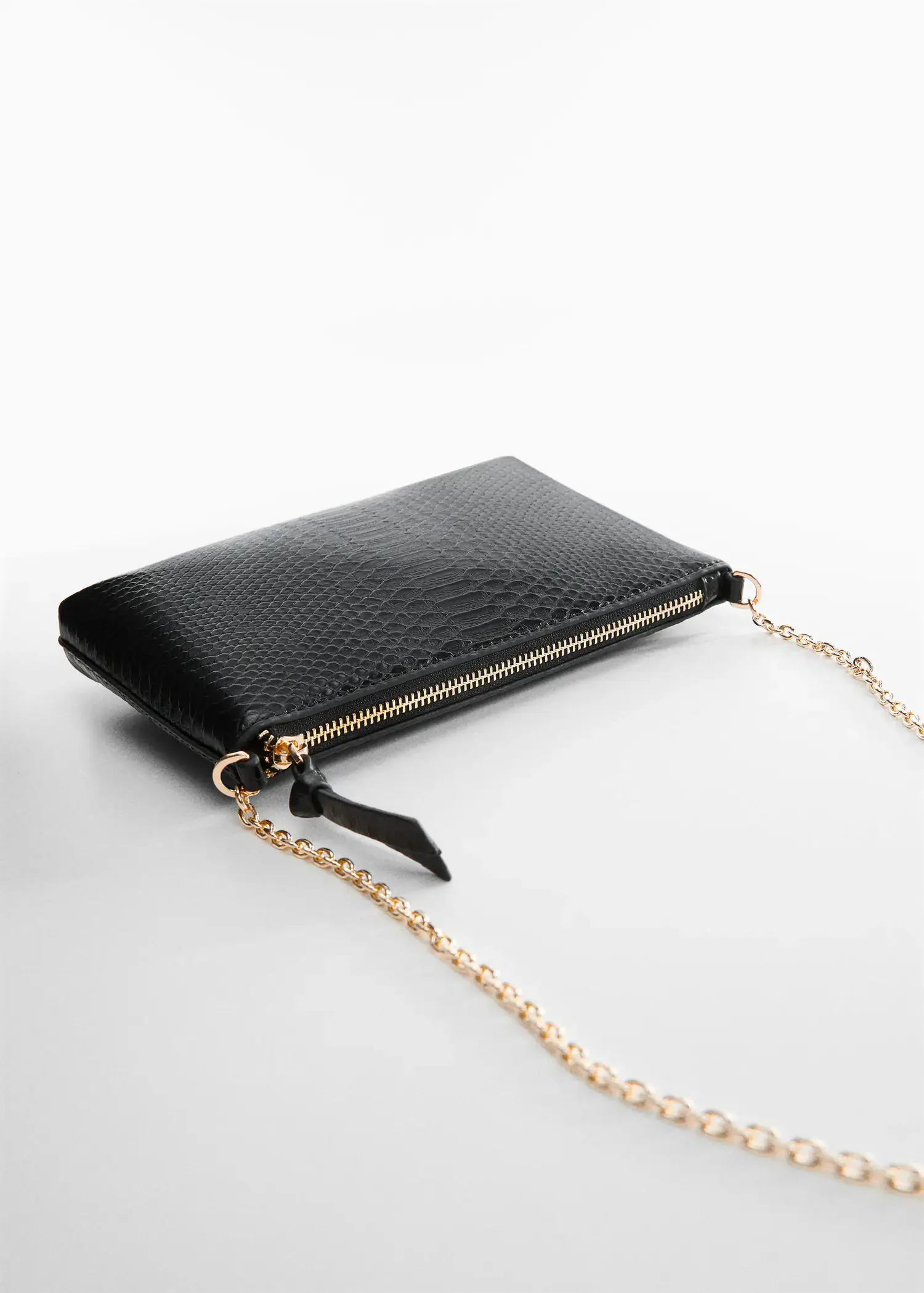 Mango Coco chain bag. a black purse with a gold chain on a table. 