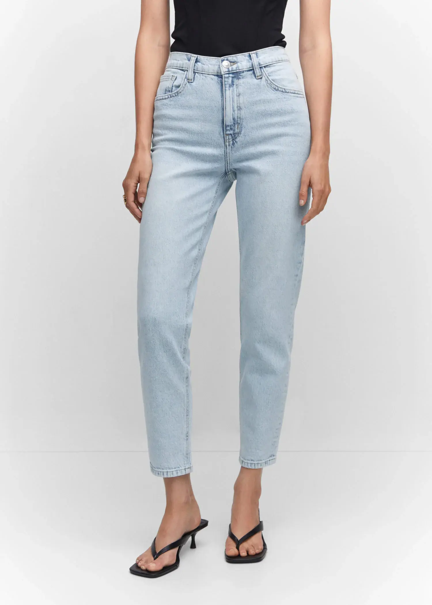 Mango Mom comfort high-rise jeans. a person wearing light blue jeans and a white shirt. 