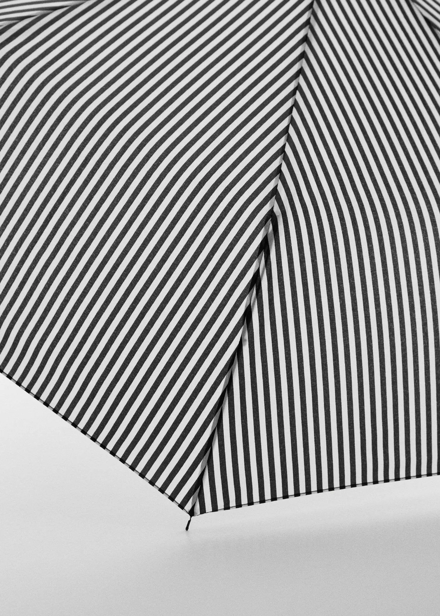Mango Striped folding umbrella. a close-up view of a black and white striped umbrella. 