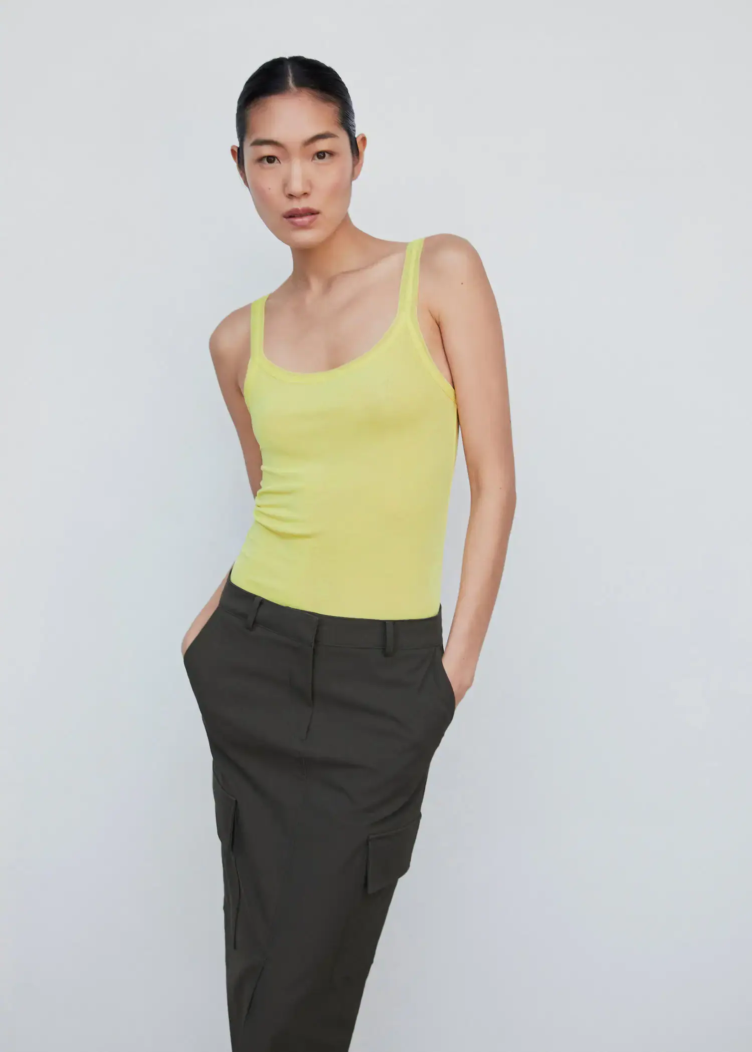 Mango Ribbed strap top. a woman wearing a yellow tank top and a black skirt. 