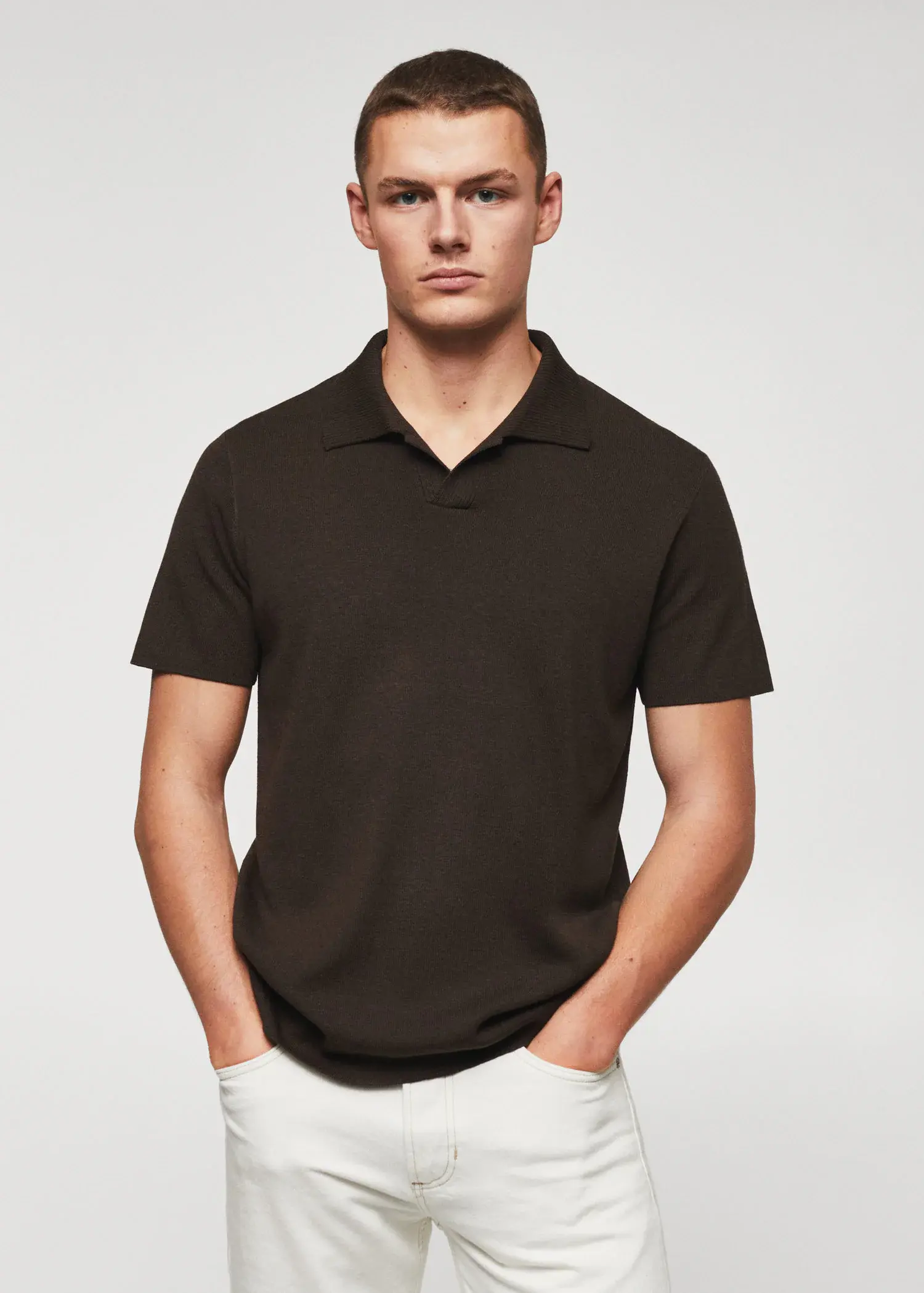 Mango Fine-knit polo shirt. a man in a black polo shirt is posing. 