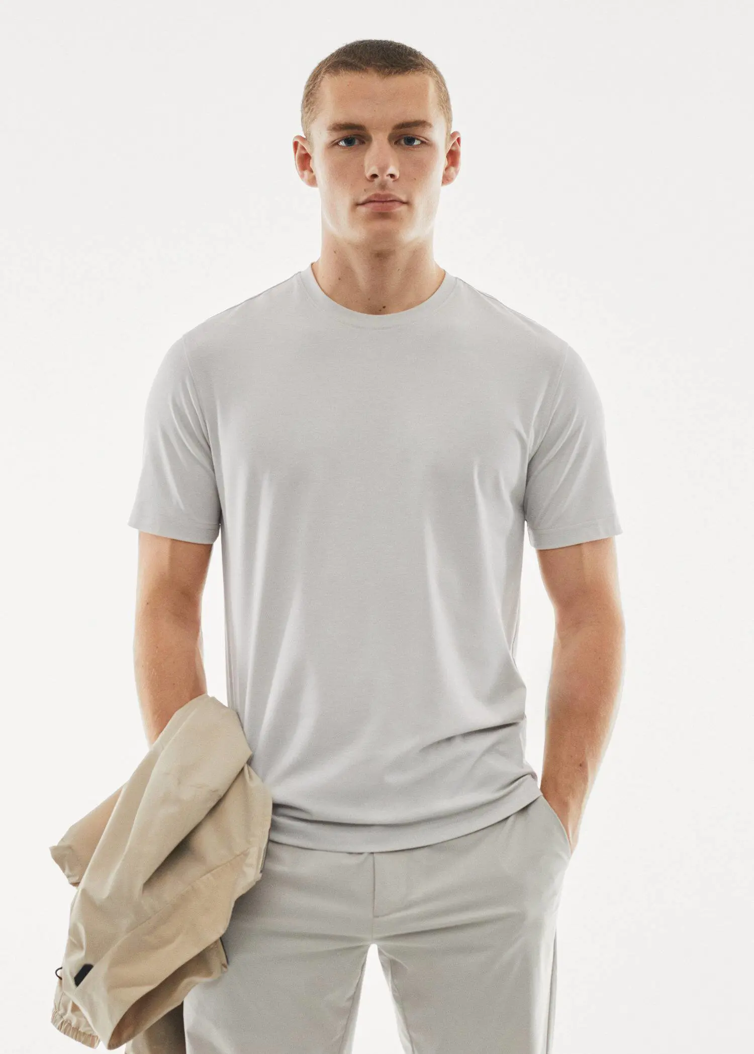 Mango Quick-drying technical t-shirt. a man in a white shirt holding a jacket. 