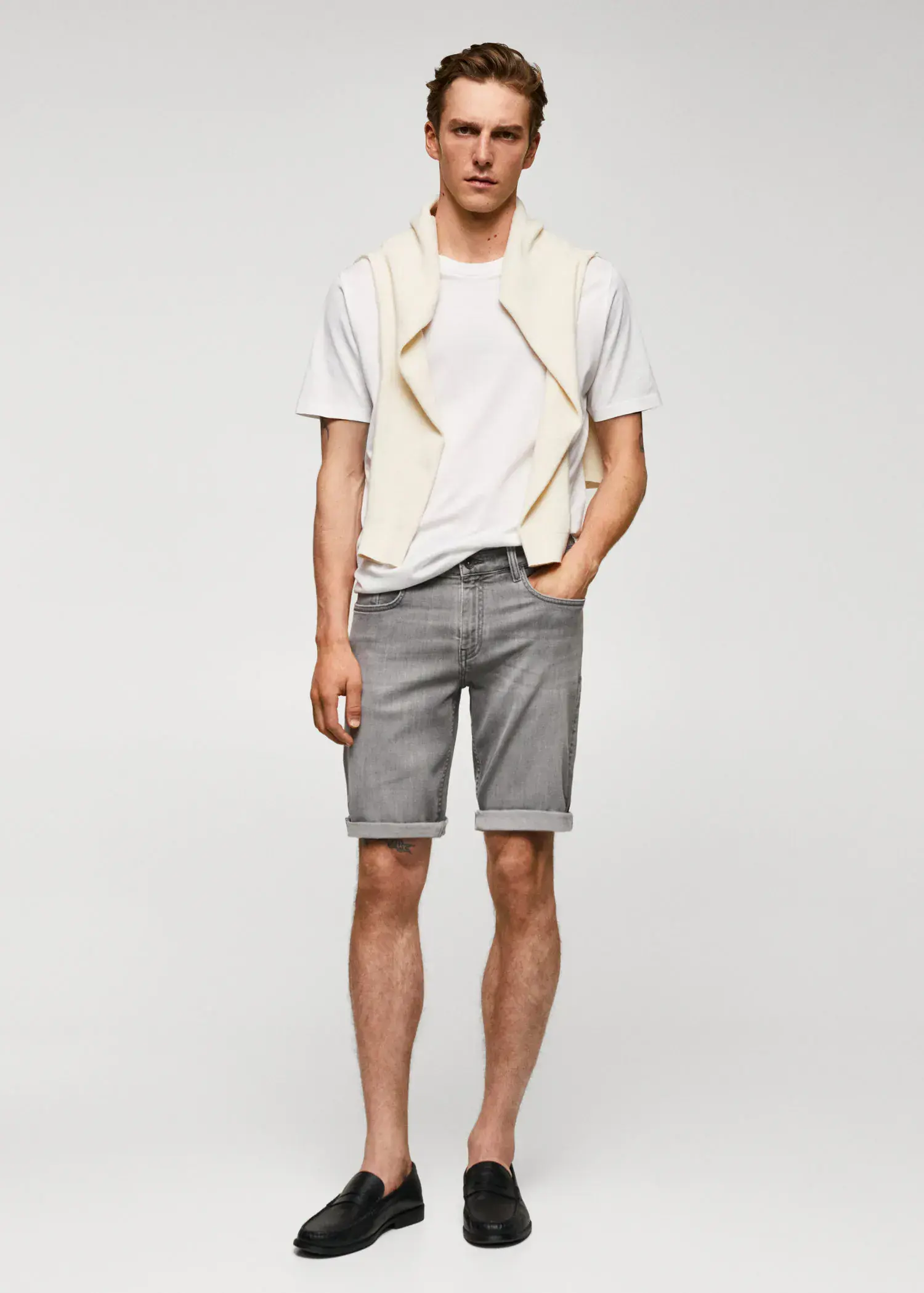 Mango Slim-fit denim bermuda shorts. a young man wearing a white shirt and a white vest. 