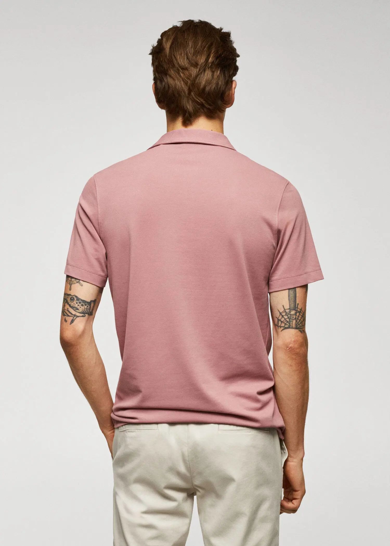 Mango Slim-fit textured cotton polo shirt. a man wearing a pink polo shirt and beige pants. 