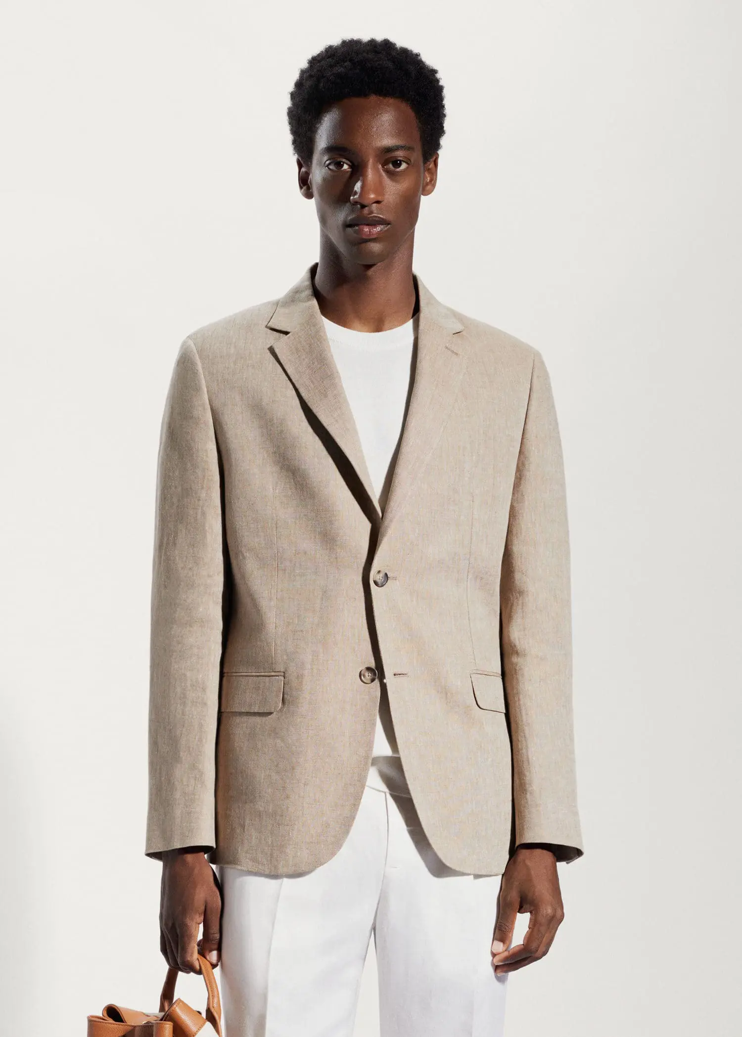 Mango 100% linen slim fit blazer. a man wearing a tan jacket and white pants. 