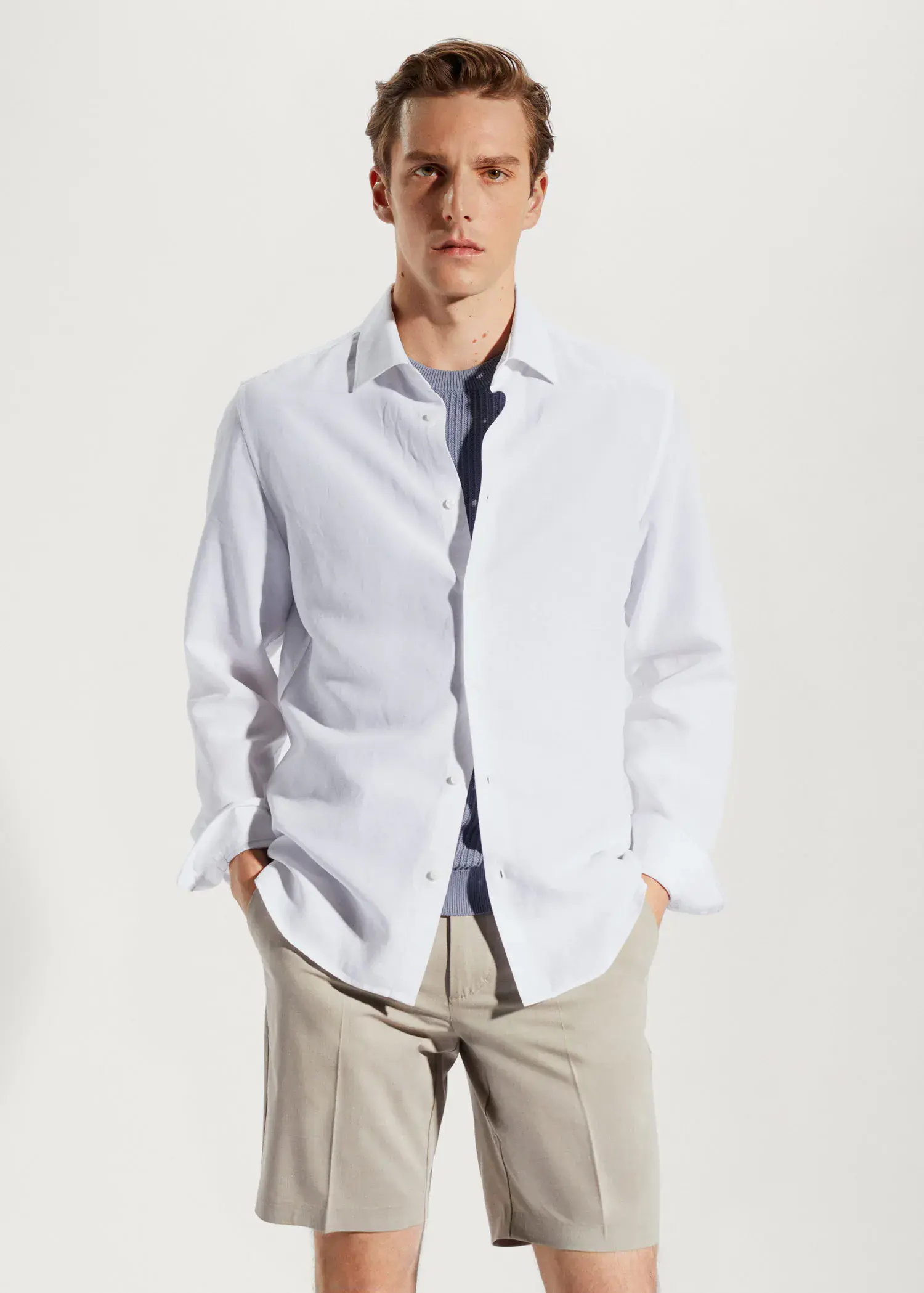 Mango Light tencel-linen shirt. a young man wearing a white shirt is standing. 