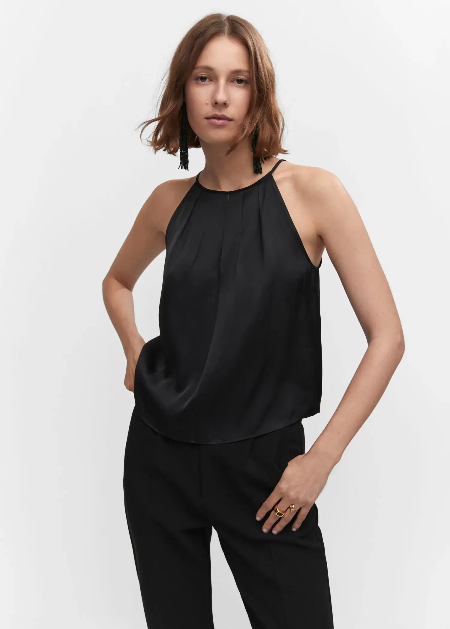 Mango Satin halter-neck top. a woman wearing a black top posing for a picture. 