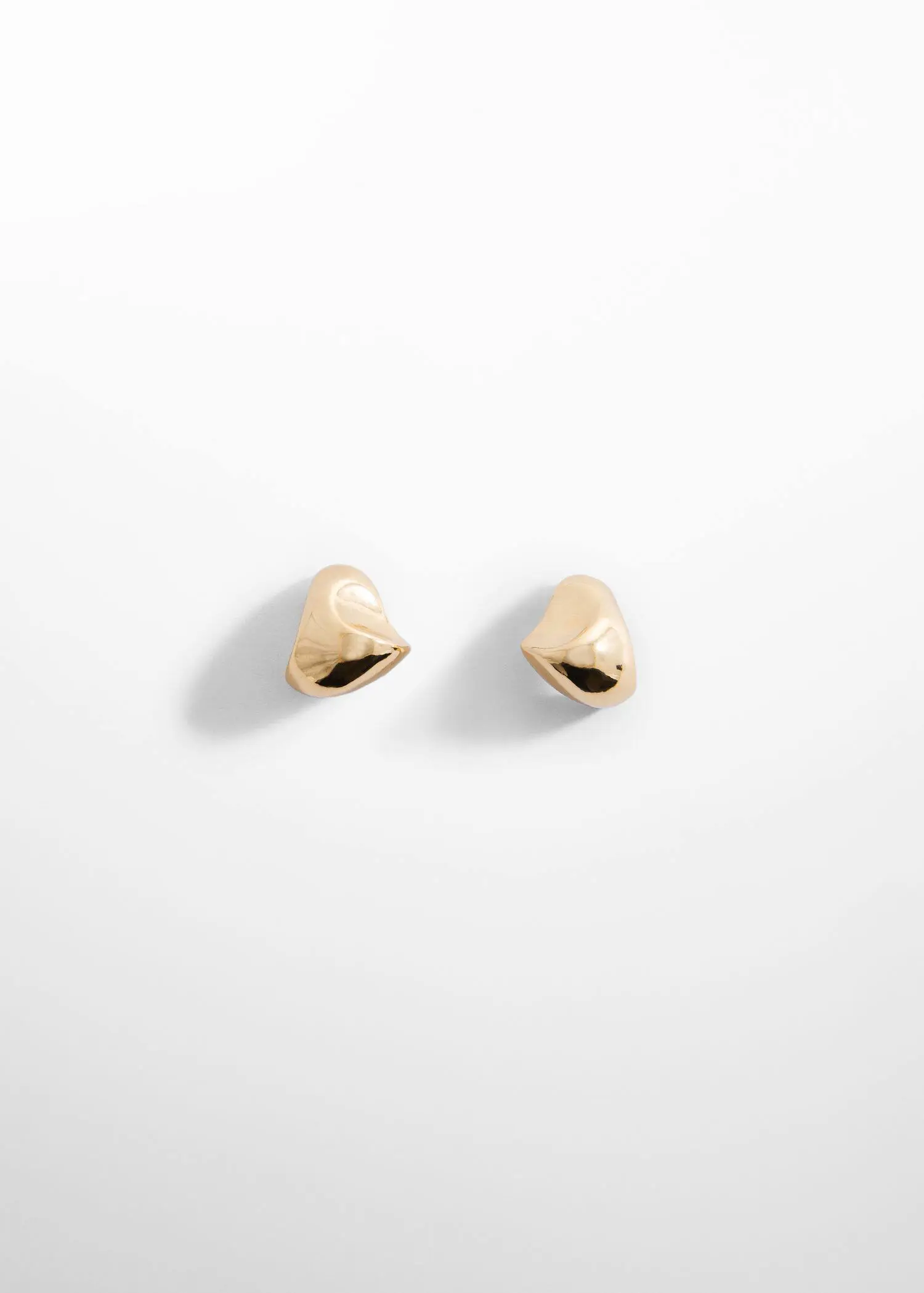 Mango Twisted earrings. a pair of gold heart shaped earrings sitting on top of a white surface. 