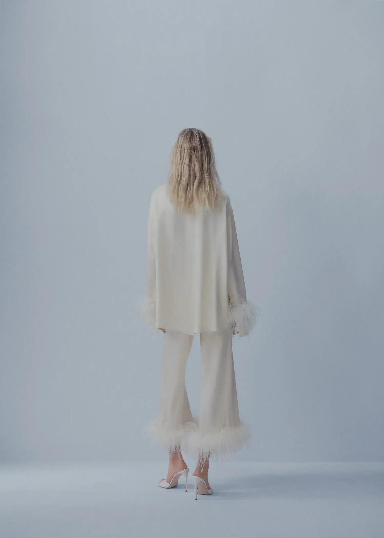 Mango Satin shirt with feather detail. a woman in a white outfit standing in front of a white wall. 