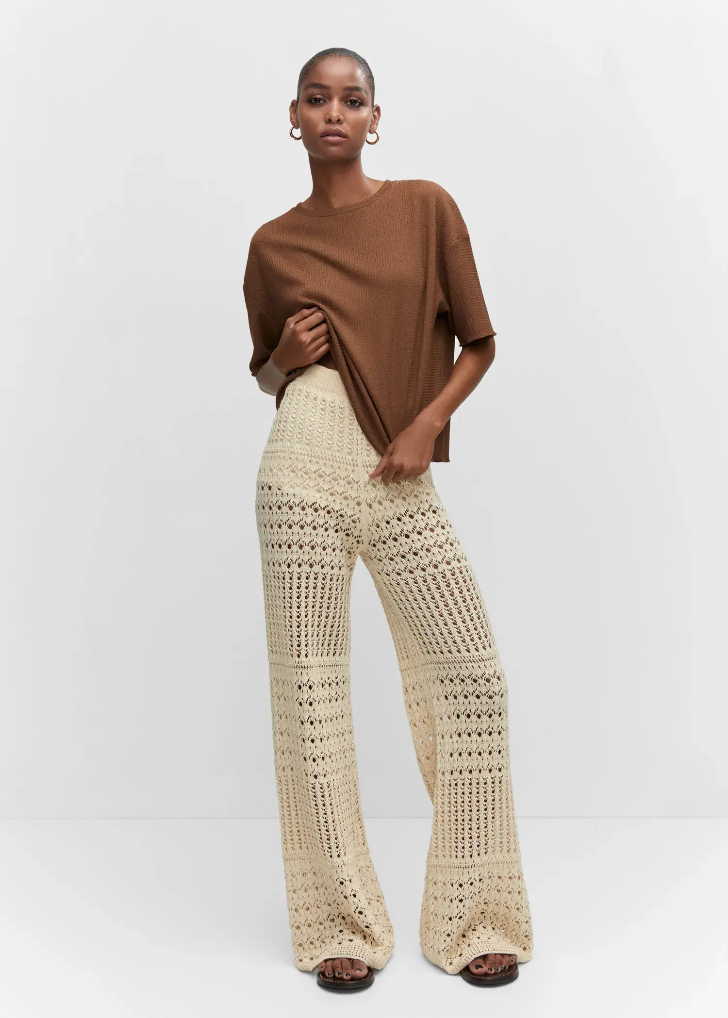Mango Oversized textured t-shirt. a woman in a brown shirt and white pants. 