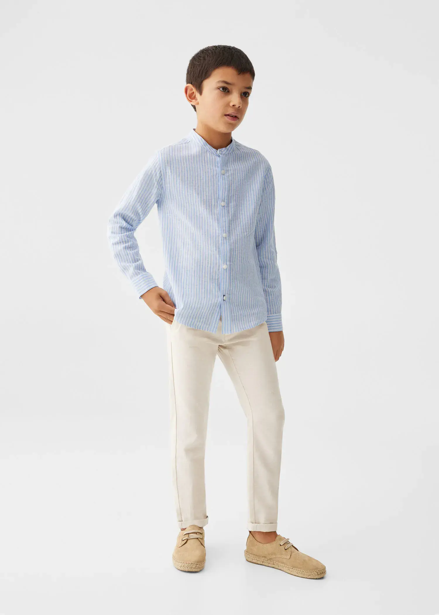 Mango KIDS/ Linen chinos. a young boy wearing a light blue dress shirt and white pants. 