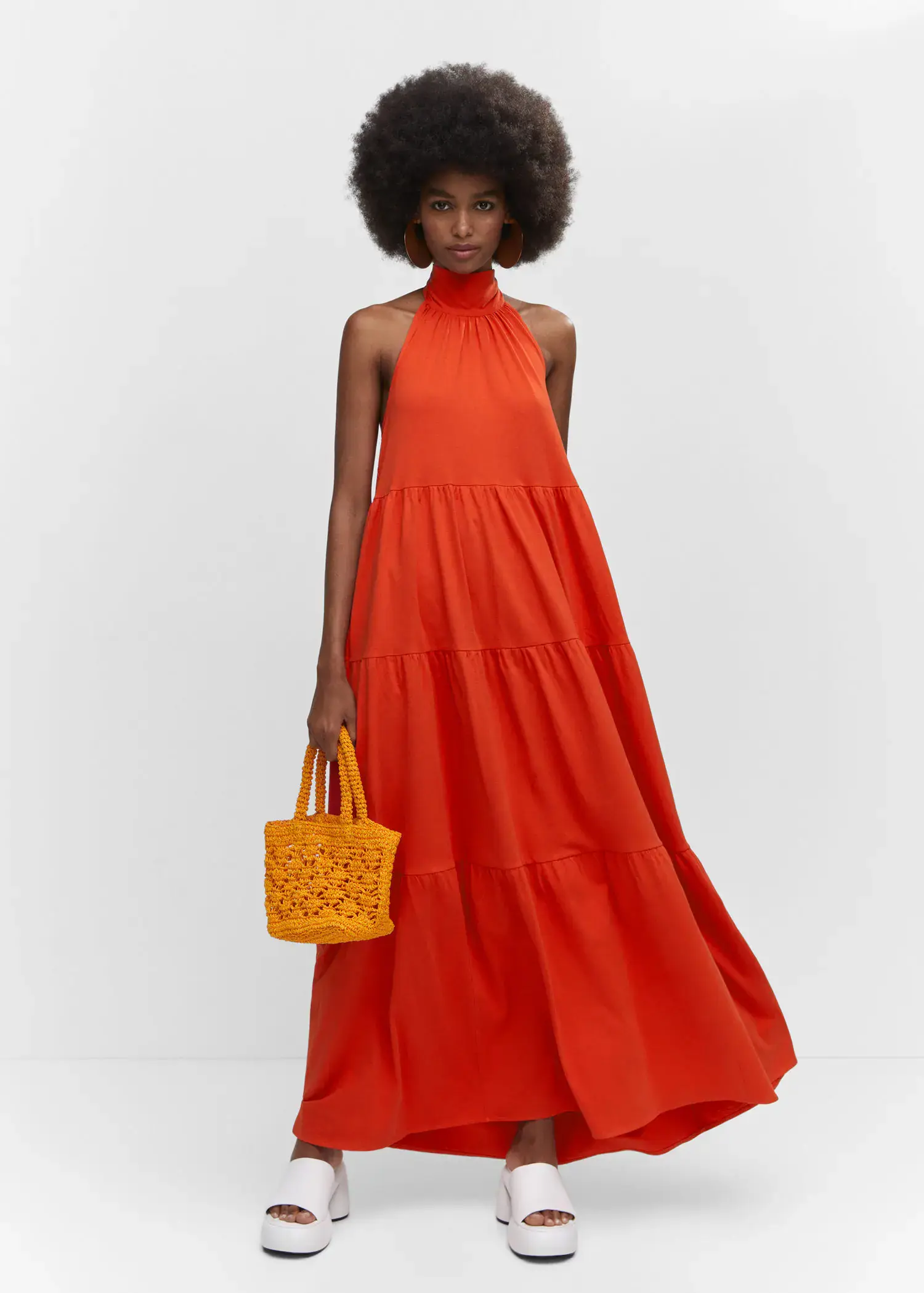 Mango Halter-neck open-back dress. a woman in a red dress holding a yellow bag. 