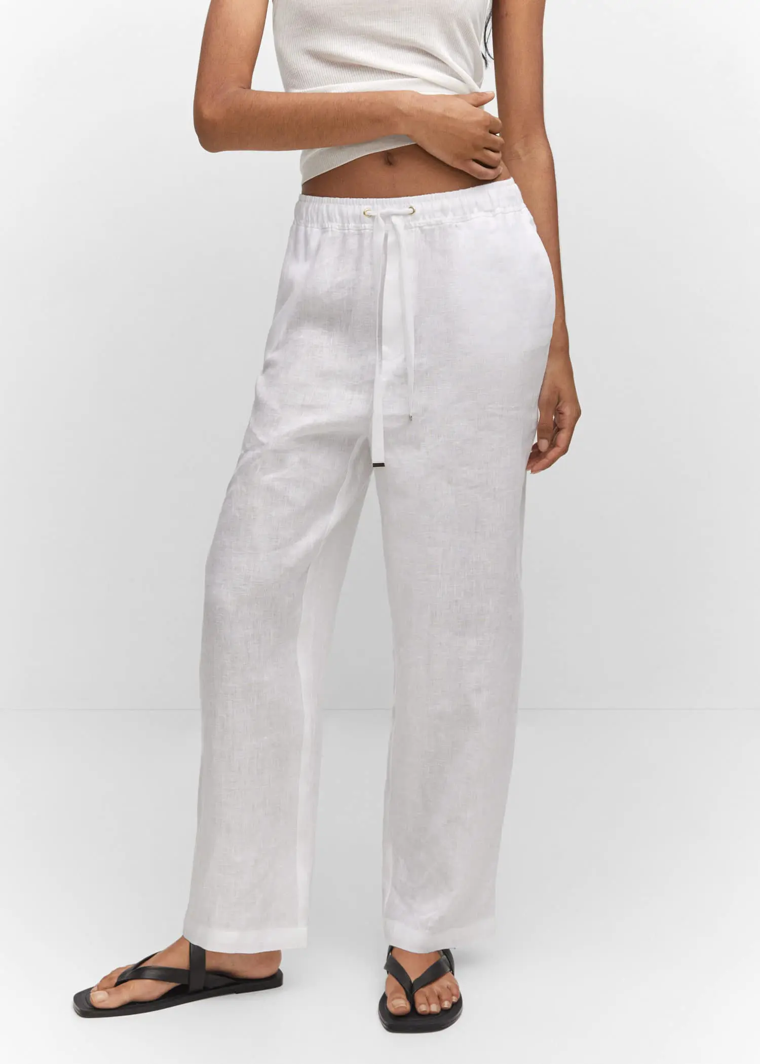 Mango Bow linen trousers. a woman wearing white pants and a white top. 