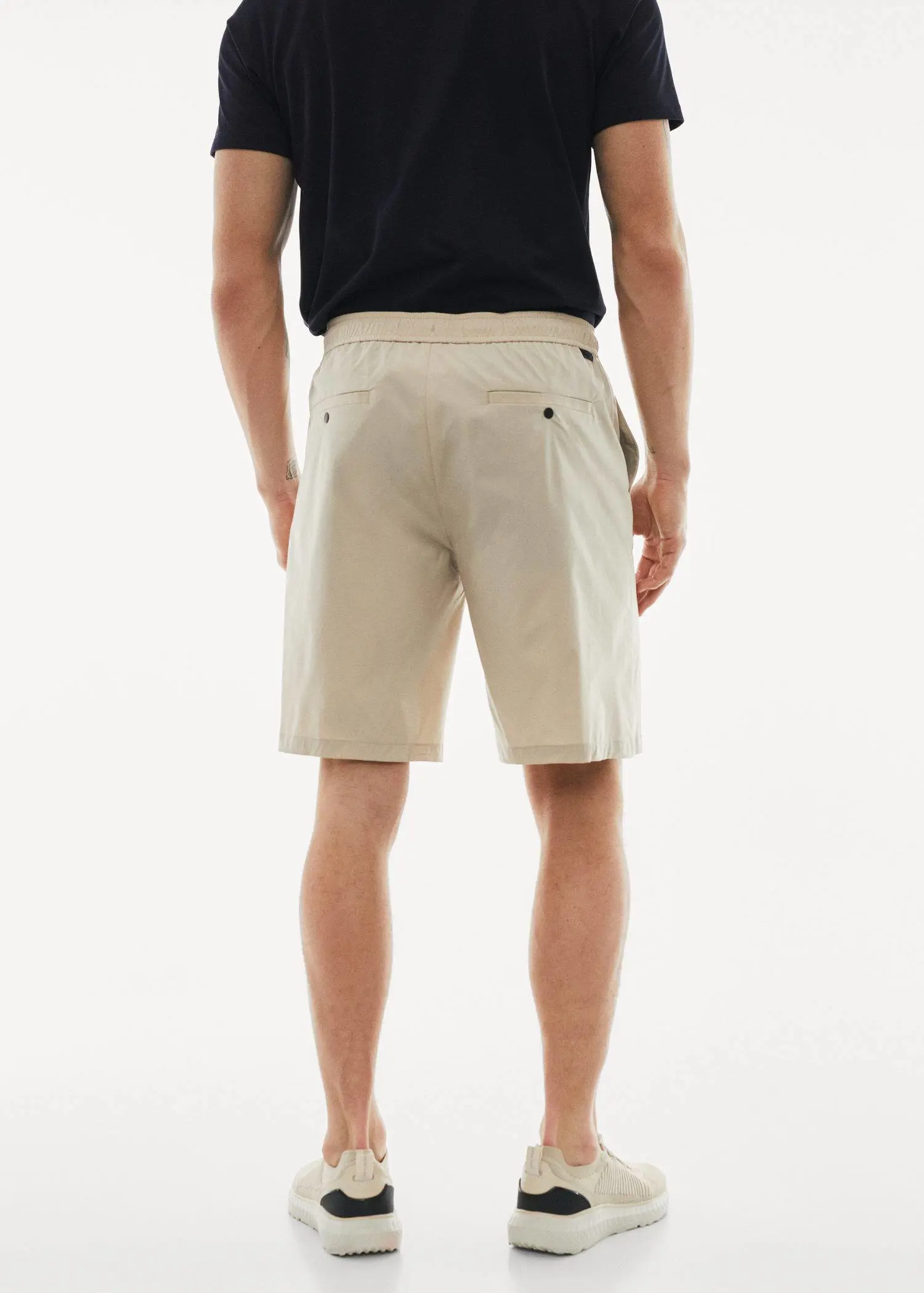 Mango Water-repellent technical bermuda shorts. a man wearing a pair of beige shorts. 