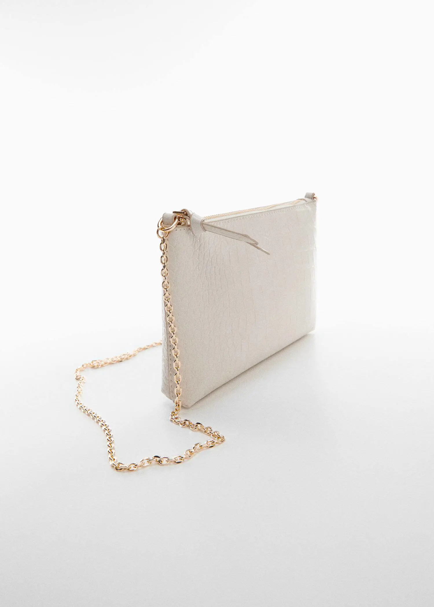 Mango Coco chain bag. a white purse with a gold chain on a table. 