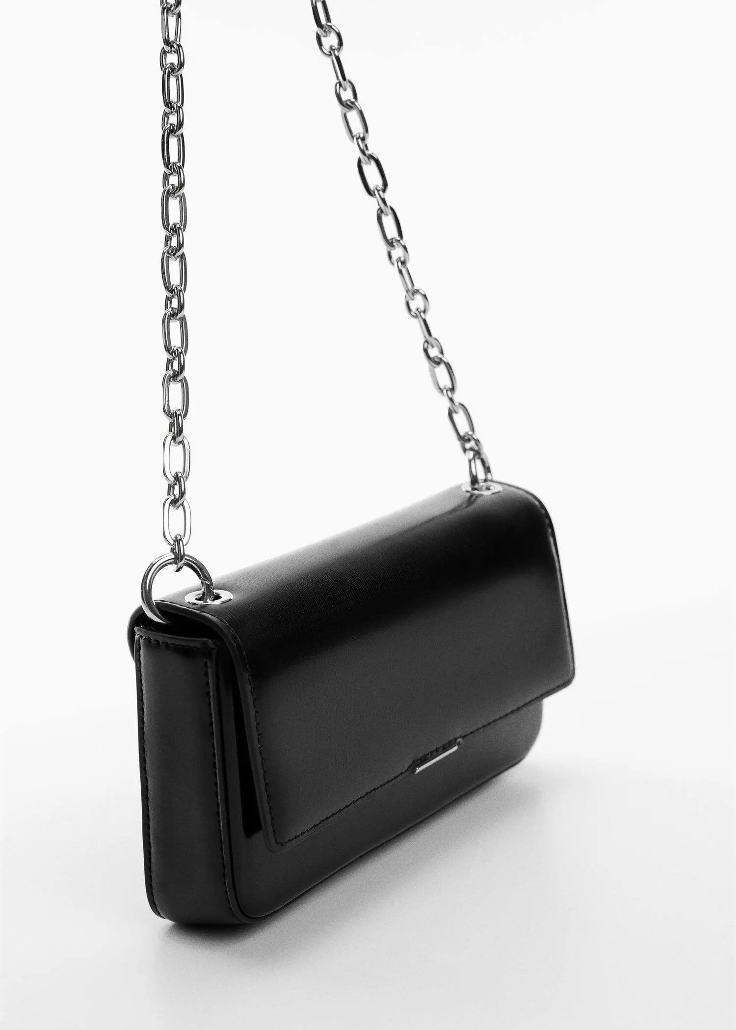Mango Flap chain bag. a black purse with a silver chain on a table. 