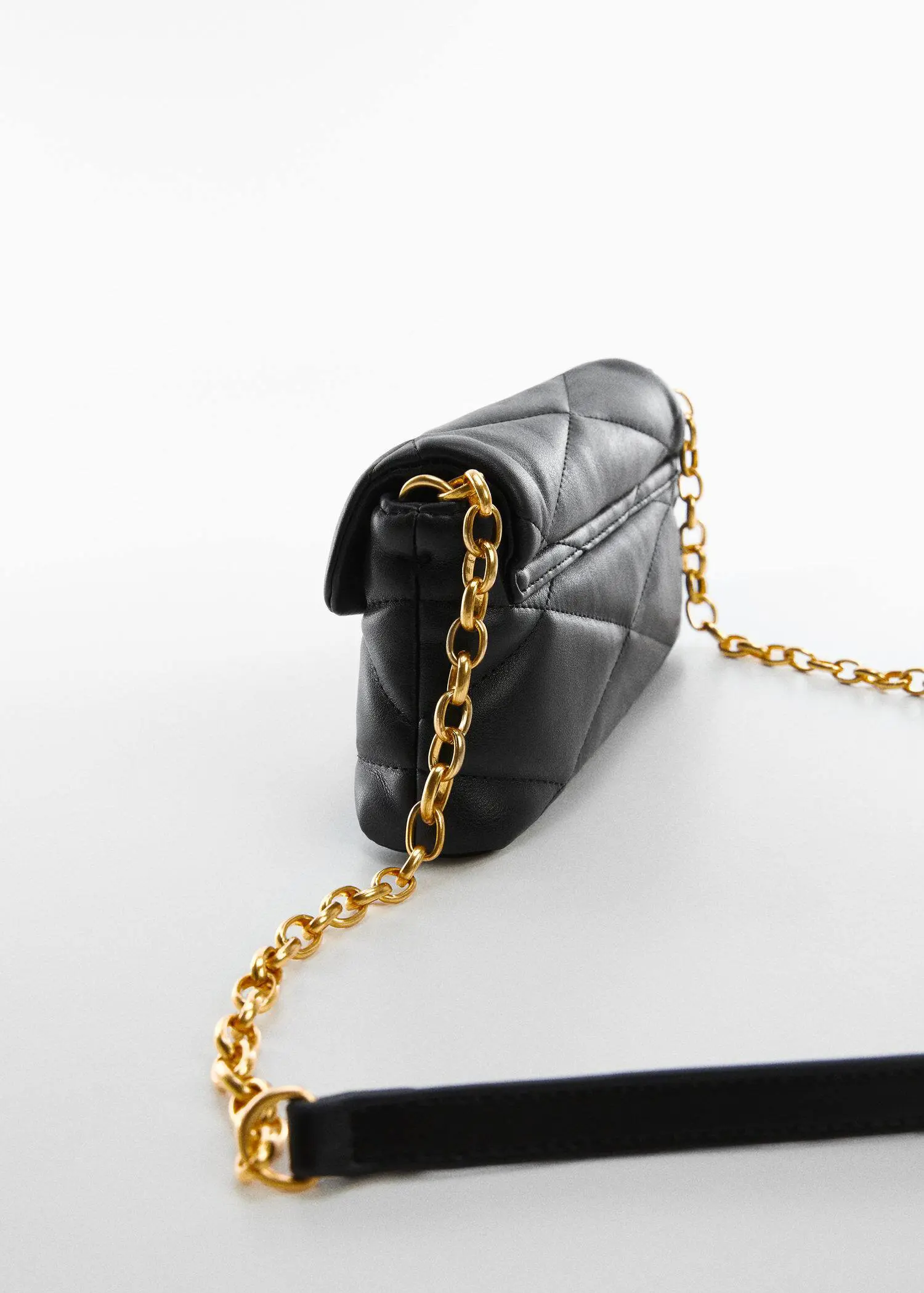 Mango Quilted chain bag. a close up of a black purse on a white surface 