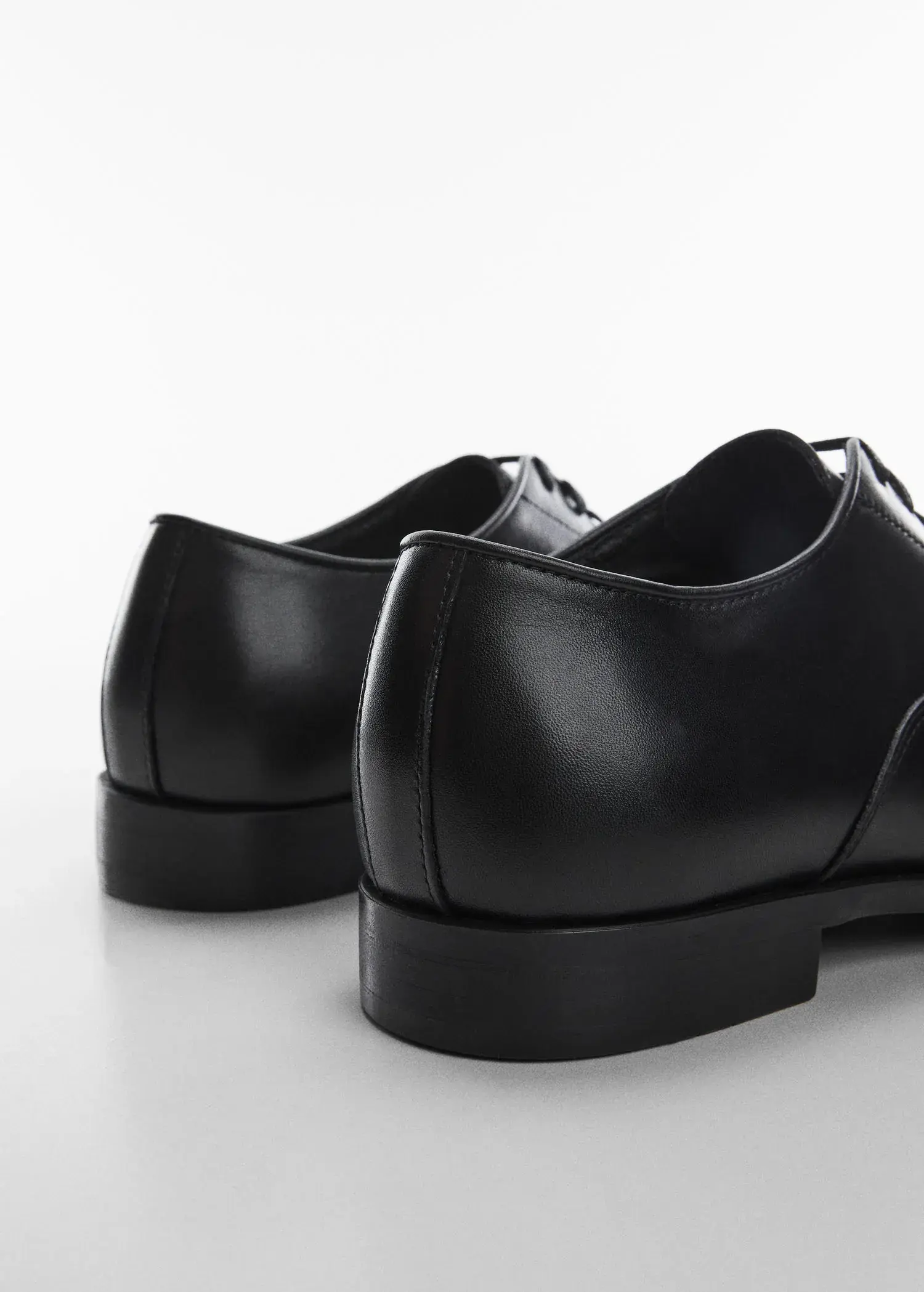 Mango Elongated leather suit shoes. a close up of a pair of black shoes. 