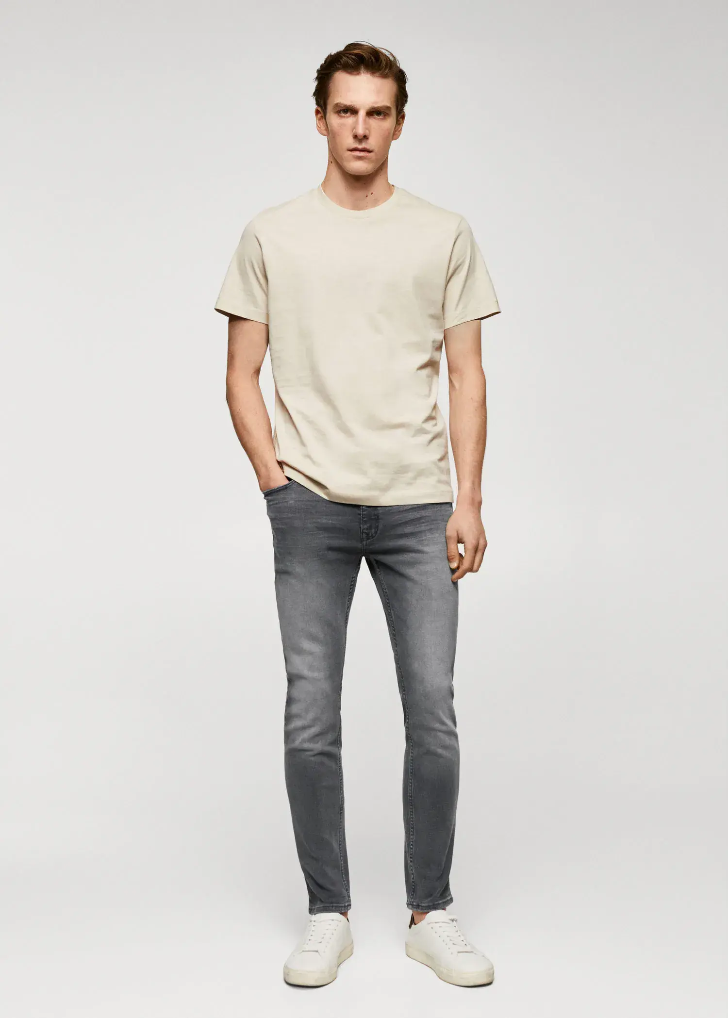Mango Jude skinny-fit jeans. a man standing with his hands in his pockets. 