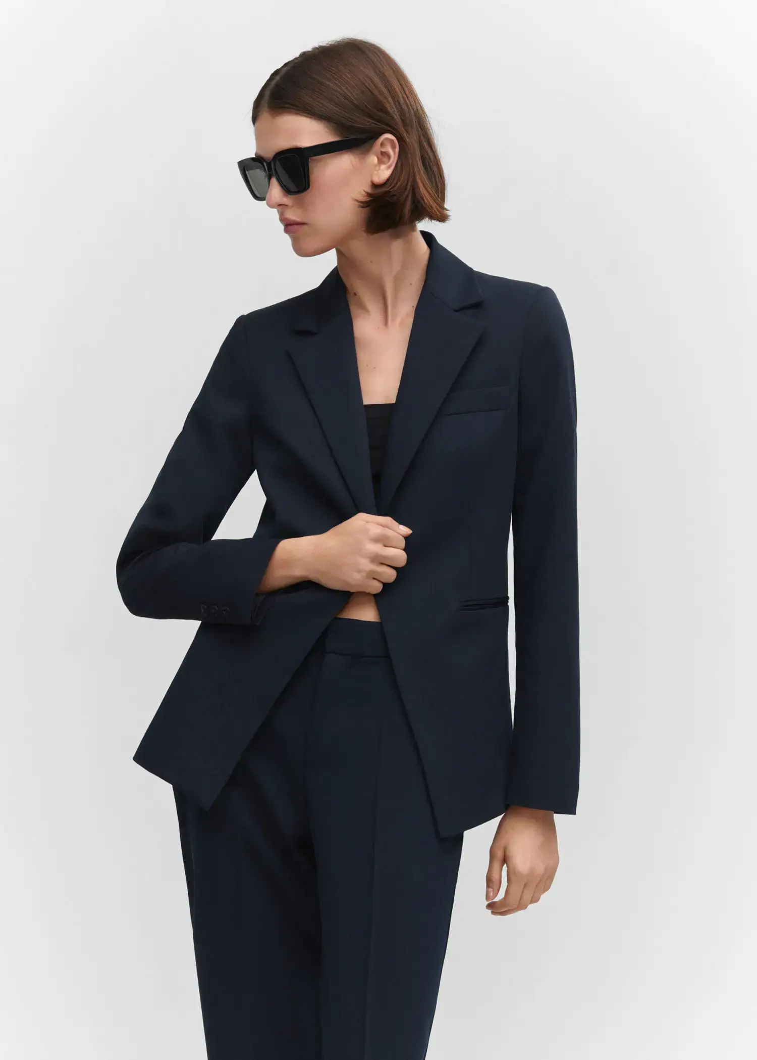 Mango Fitted suit jacket. a woman wearing a black suit and sunglasses. 