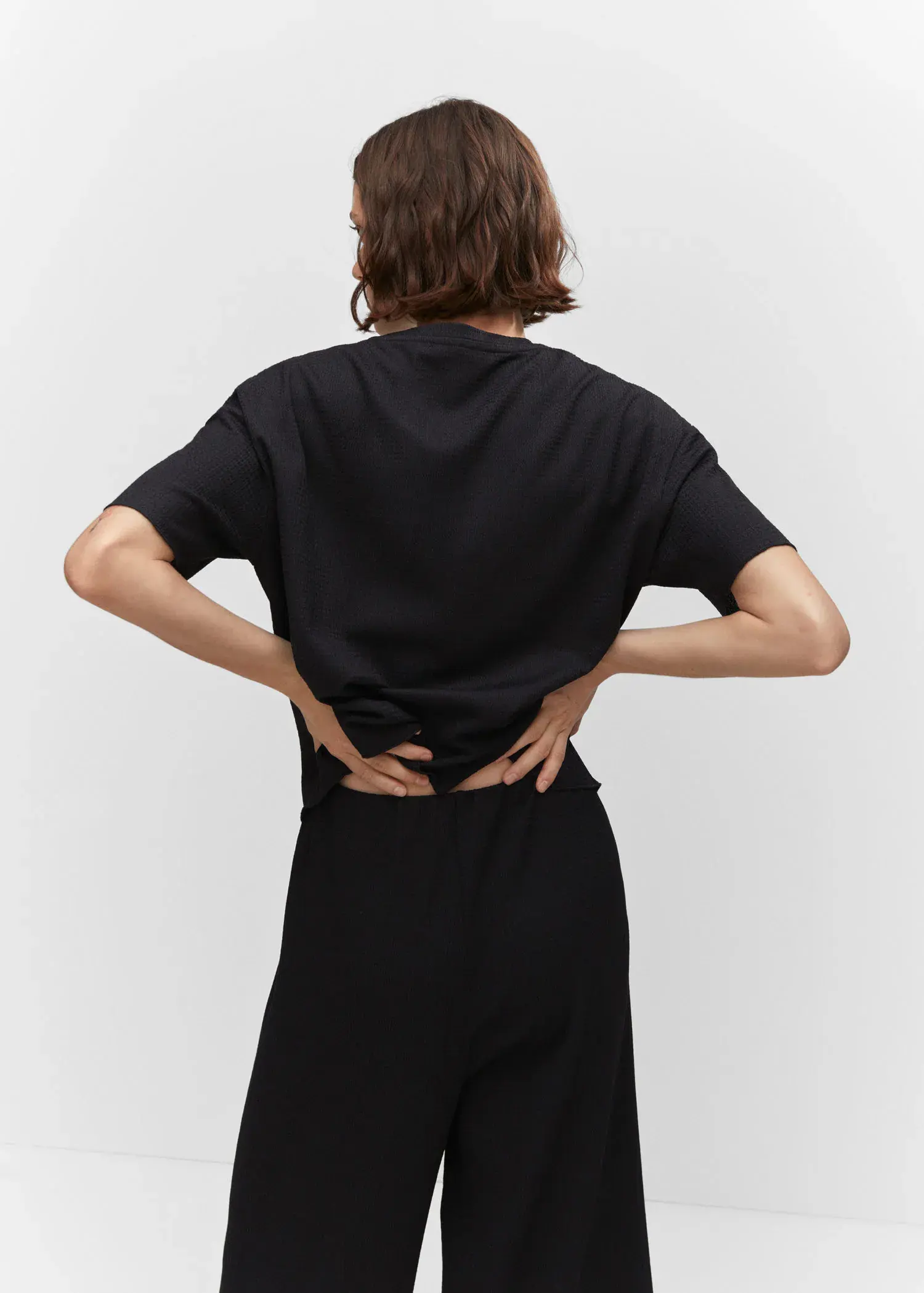 Mango Oversized textured t-shirt. a person standing with their hands on their hips. 