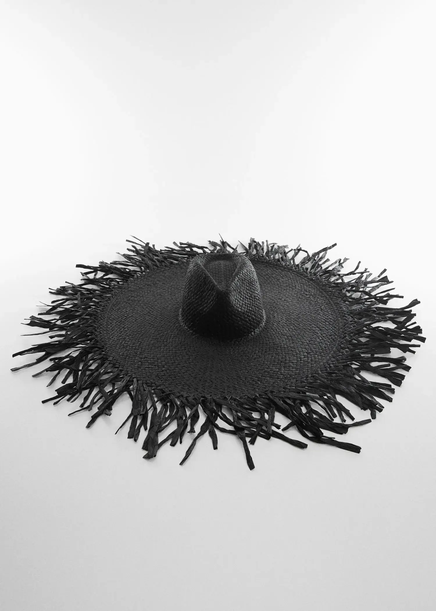 Mango Natural fibre maxi hat. a black hat is sitting on top of a white table. 