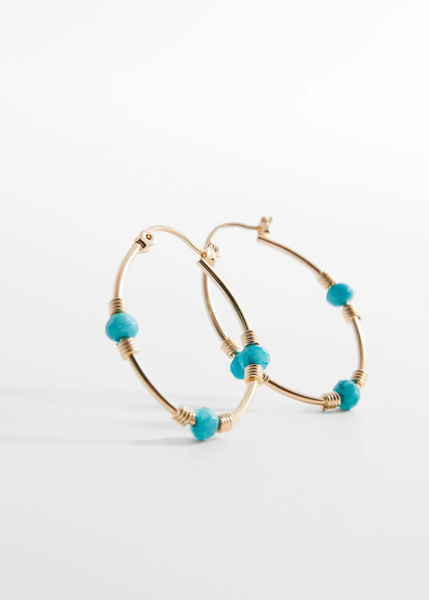 Mango Stone hoop earrings. a close up of a pair of earrings on a table 