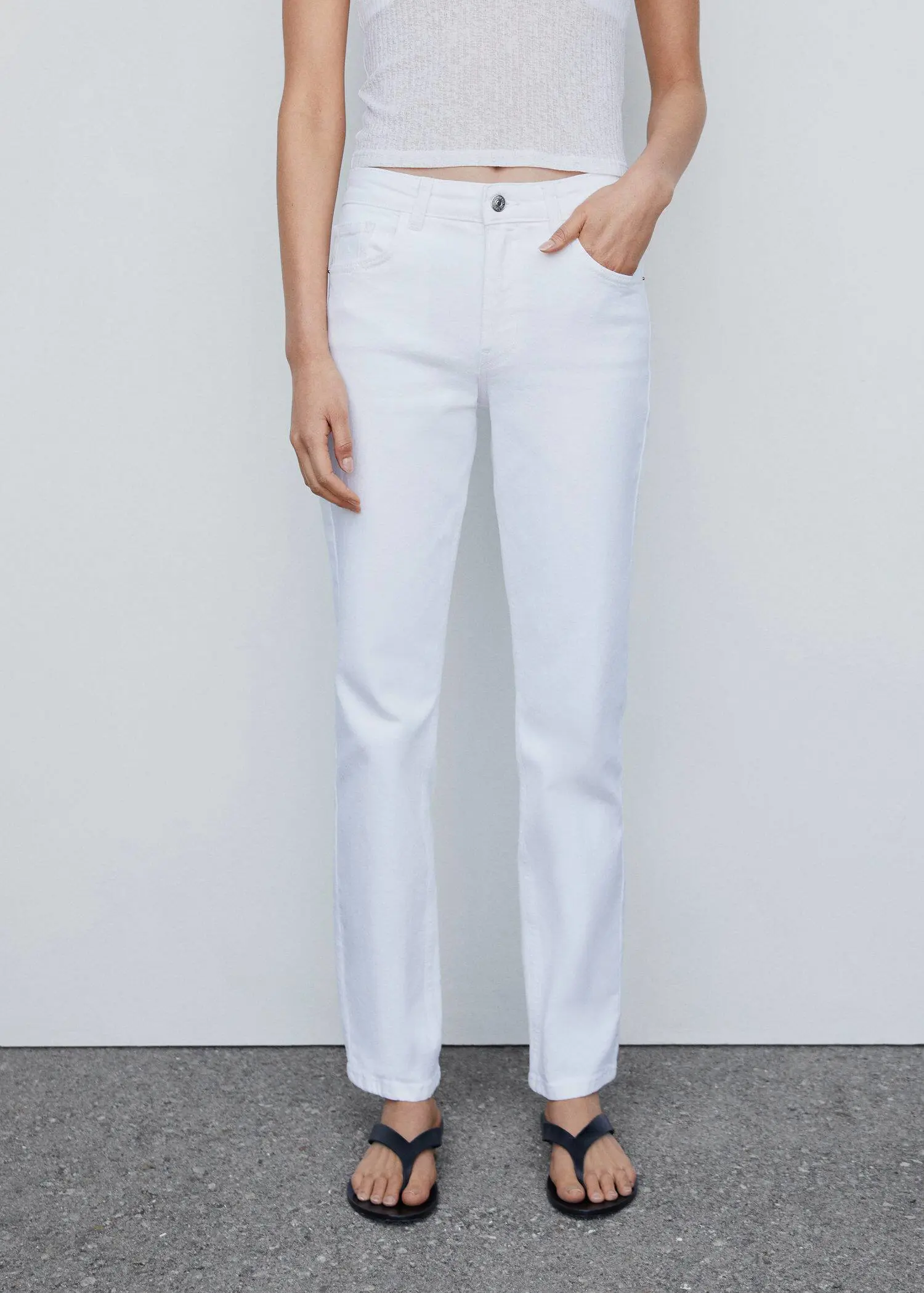 Mango Medium-comfort straight jeans. a person standing in front of a white wall. 