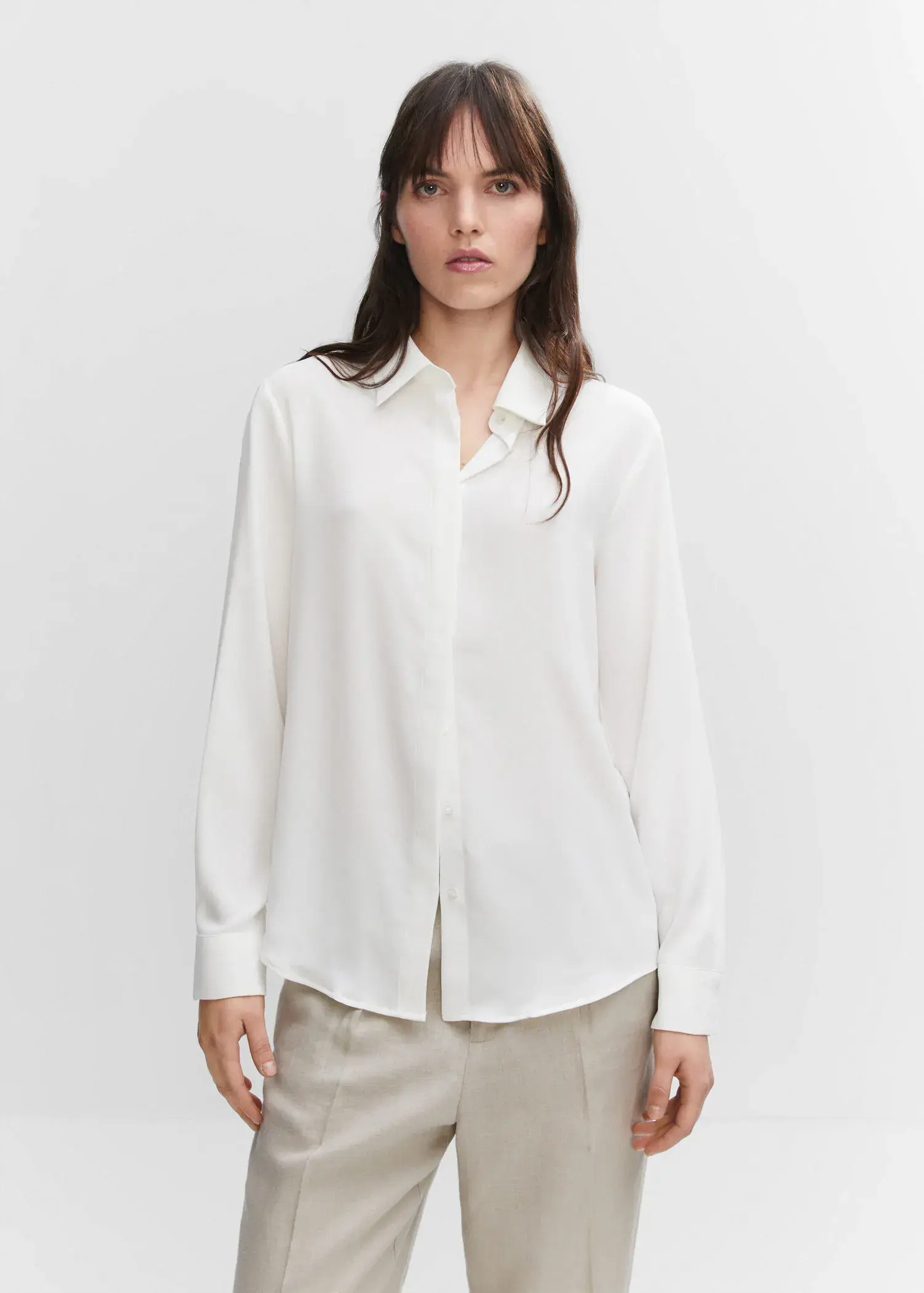 Mango Buttoned flowy shirt. a woman in a white shirt is posing for a picture. 