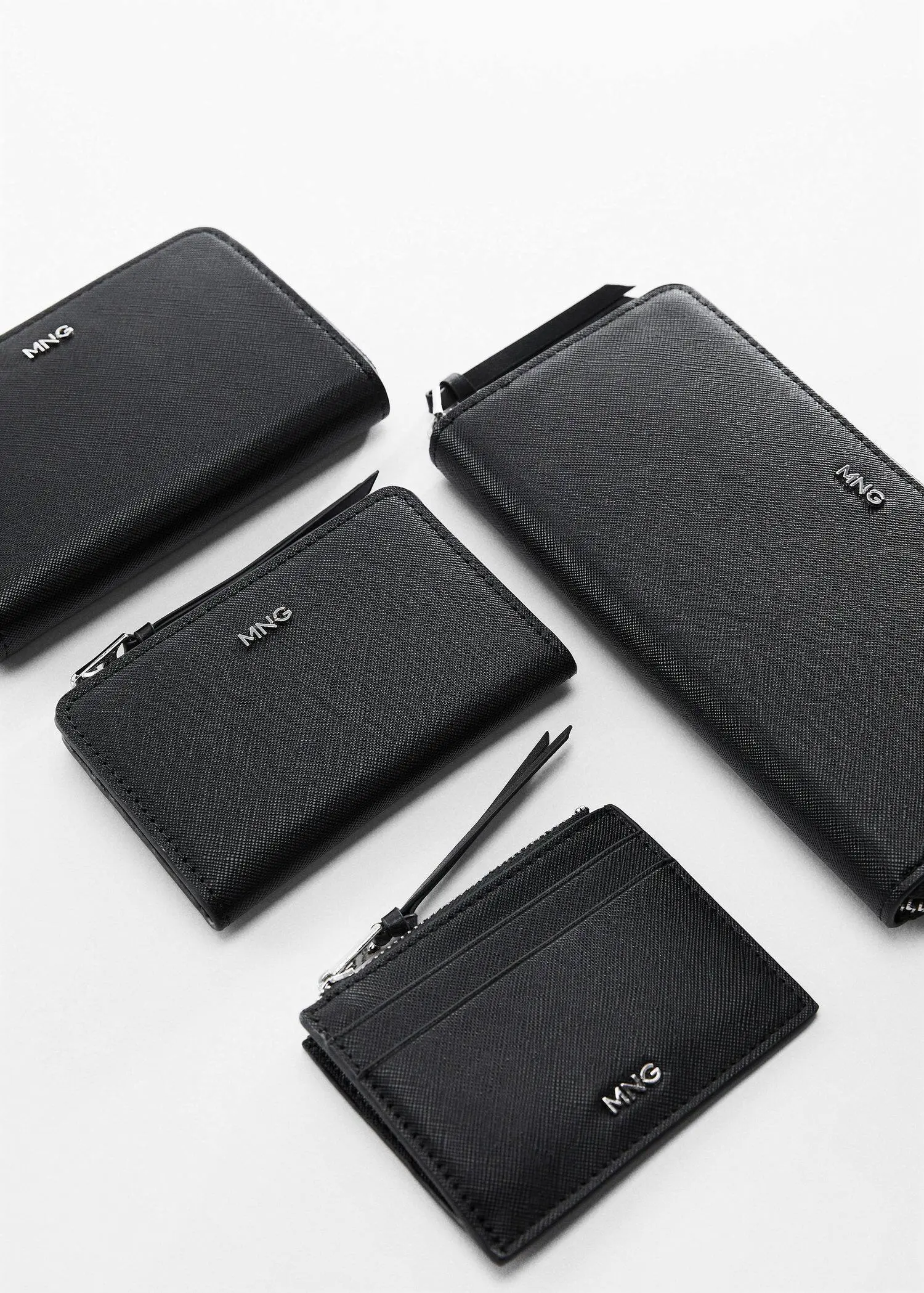 Mango Saffiano-effect wallet. four different types of black wallets on a table. 