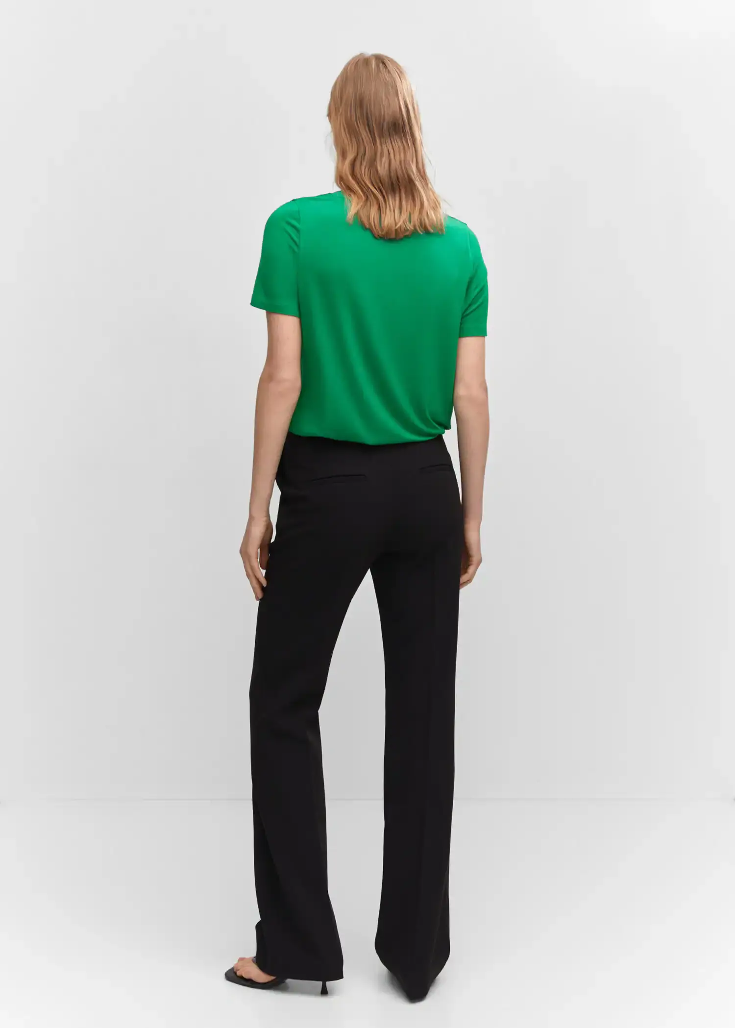Mango Low neck t-shirt. a person wearing a green shirt and black pants. 