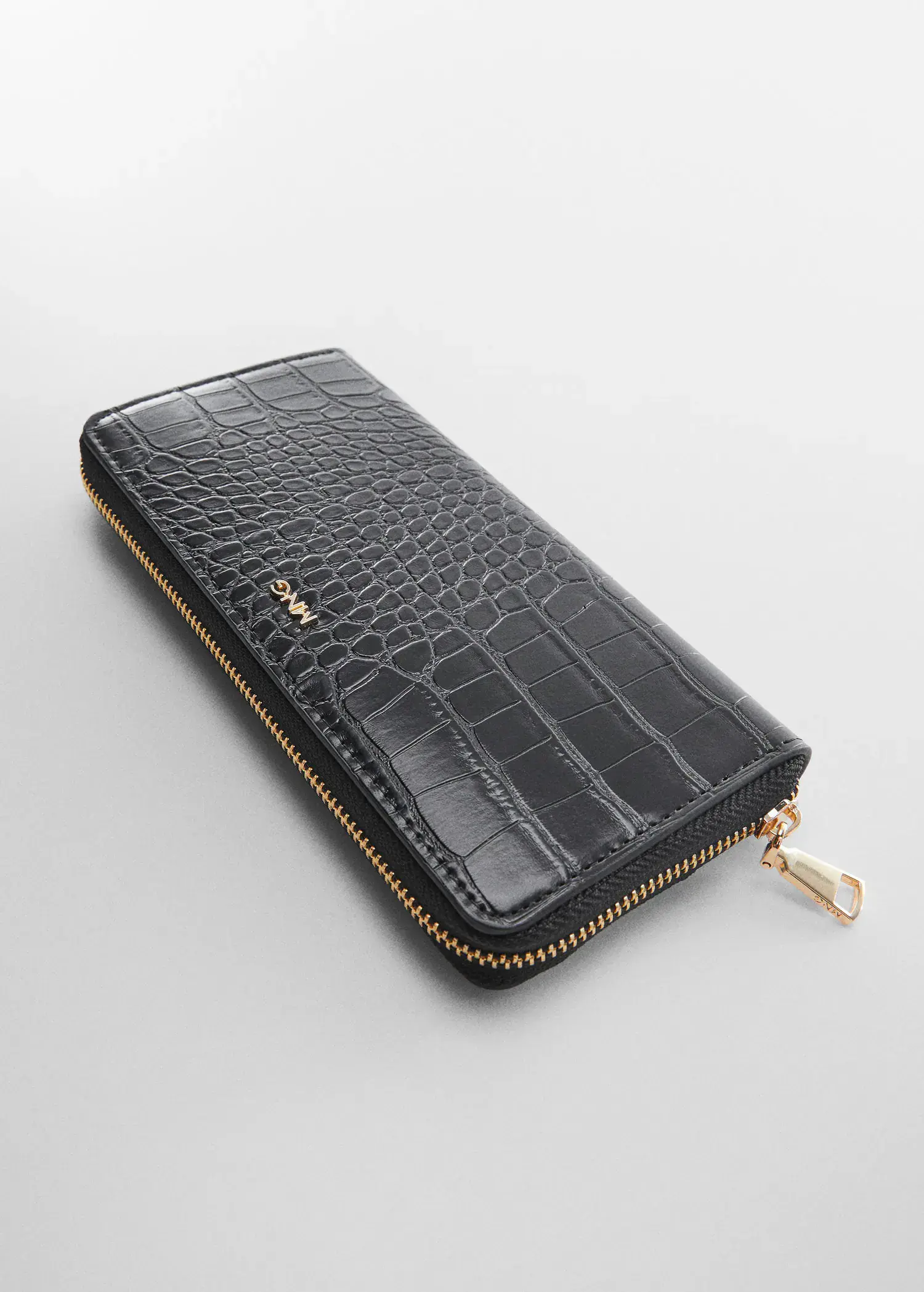 Mango Crocodile wallet with logo. a black wallet is sitting on a table. 