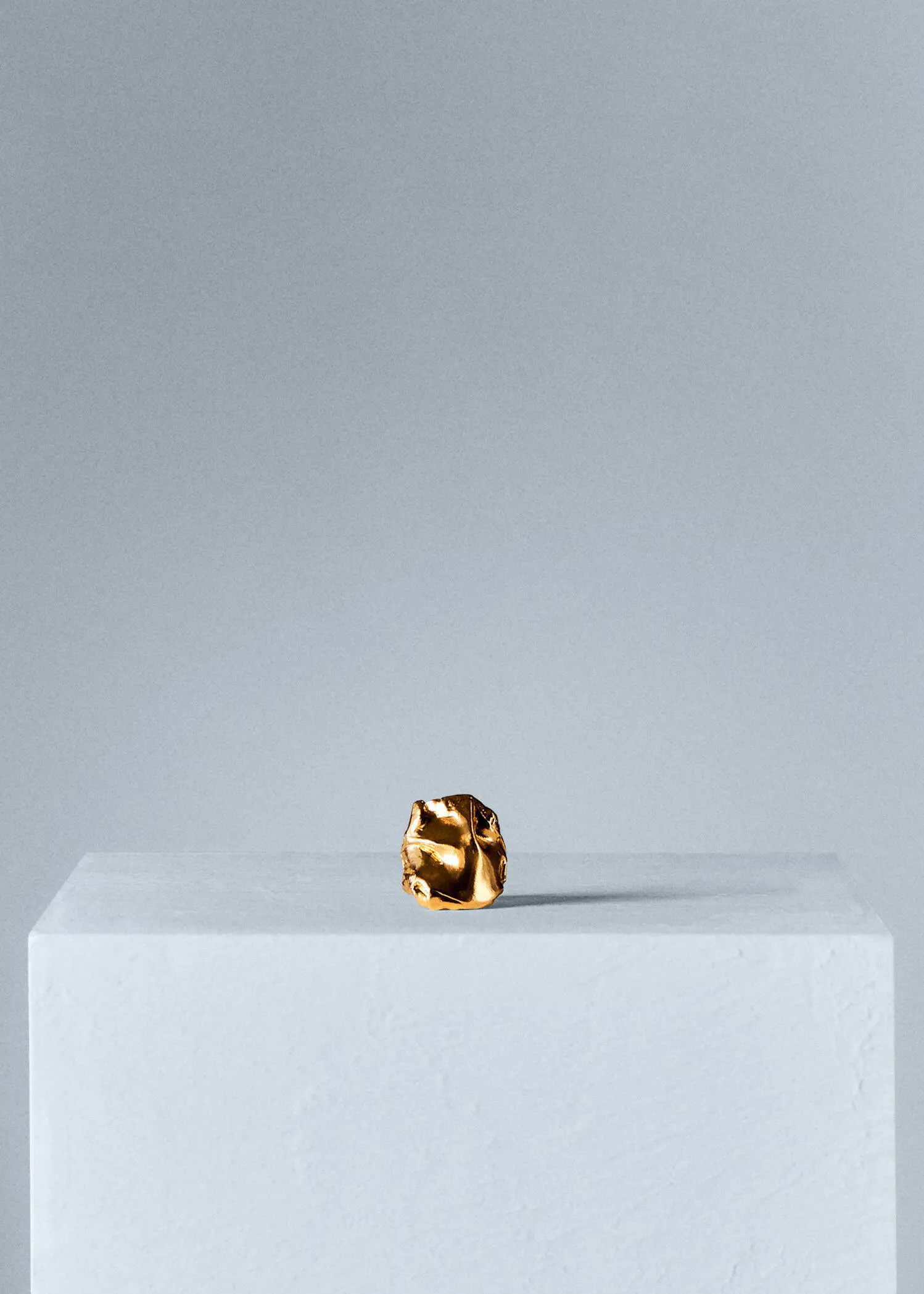 Mango 18k textured ring. a piece of metal sitting on top of a table. 