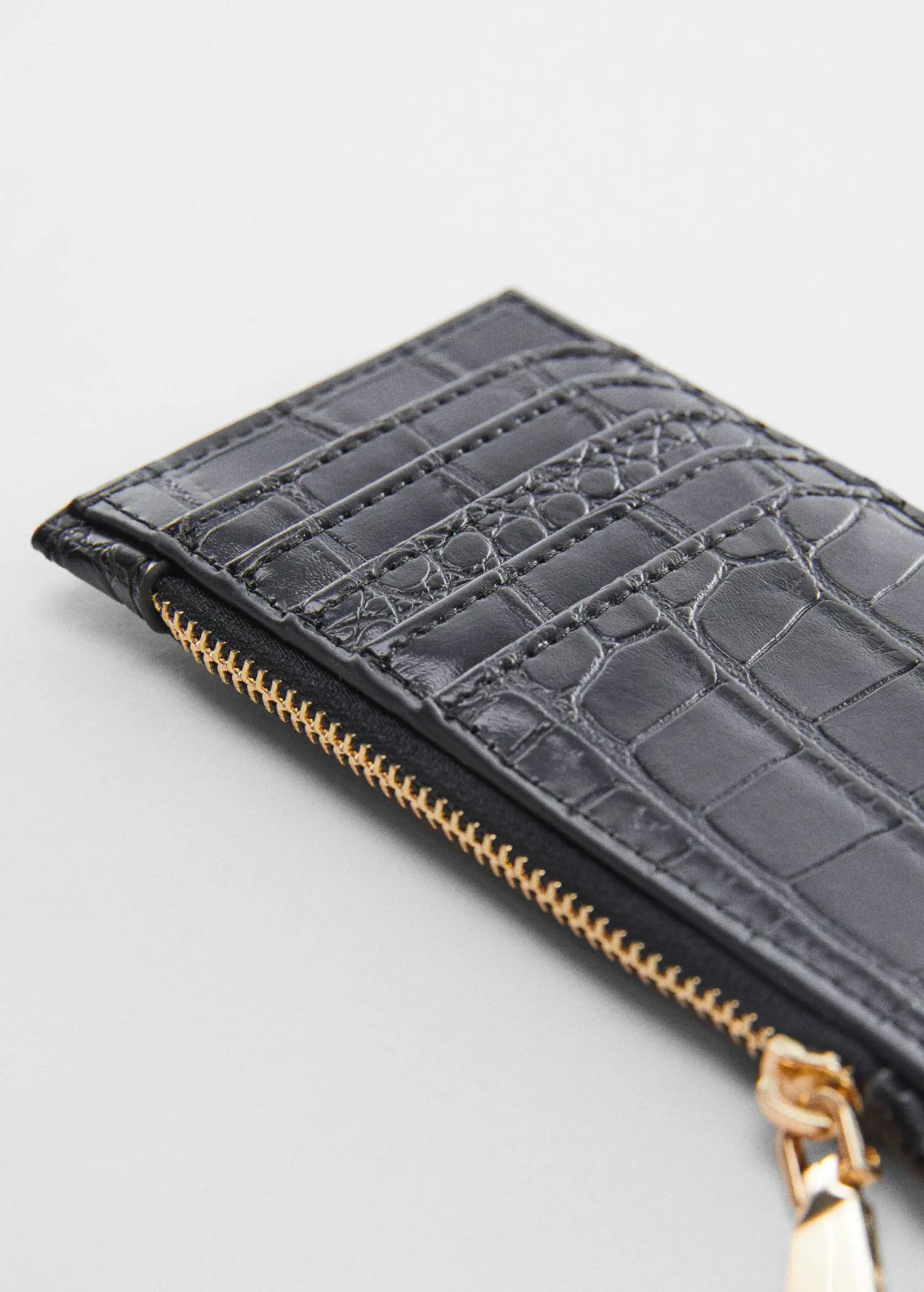 Mango Crocodile purse with logo. a close-up of the zipper of a black wallet. 