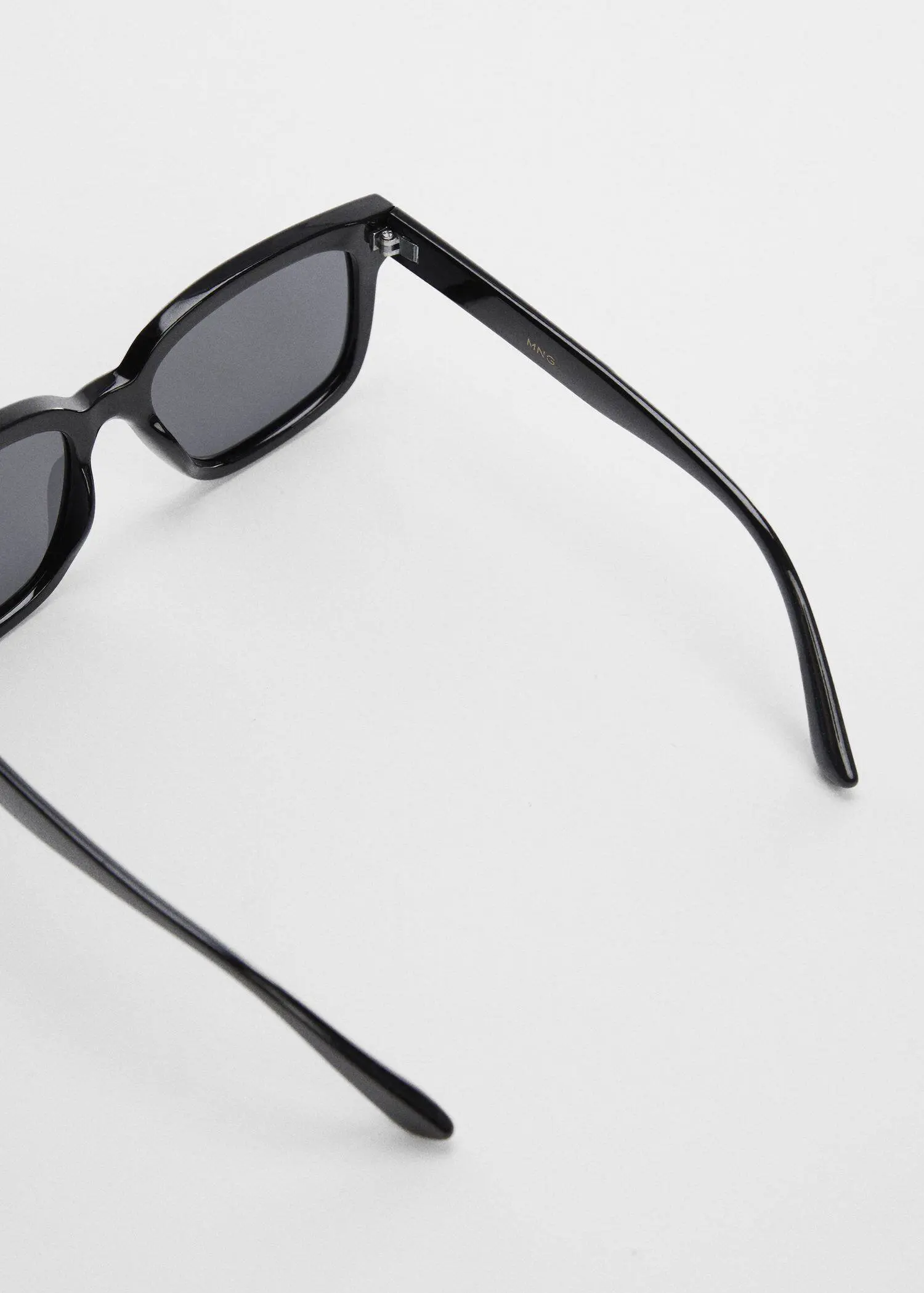 Mango Polarised sunglasses. a pair of black sunglasses on top of a white surface. 