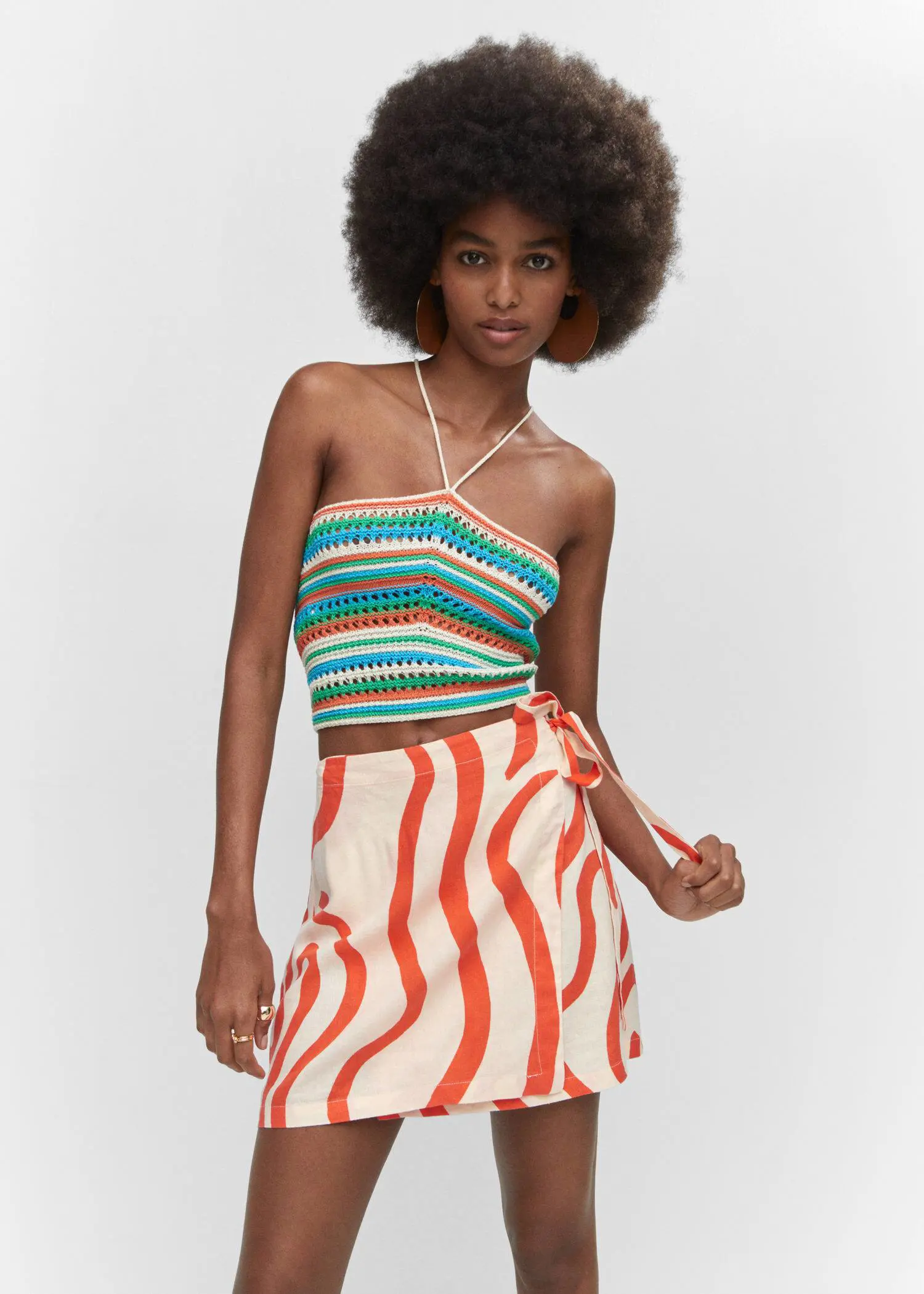 Mango Printed linen-blend skirt. a woman wearing a colorful top and a striped skirt. 