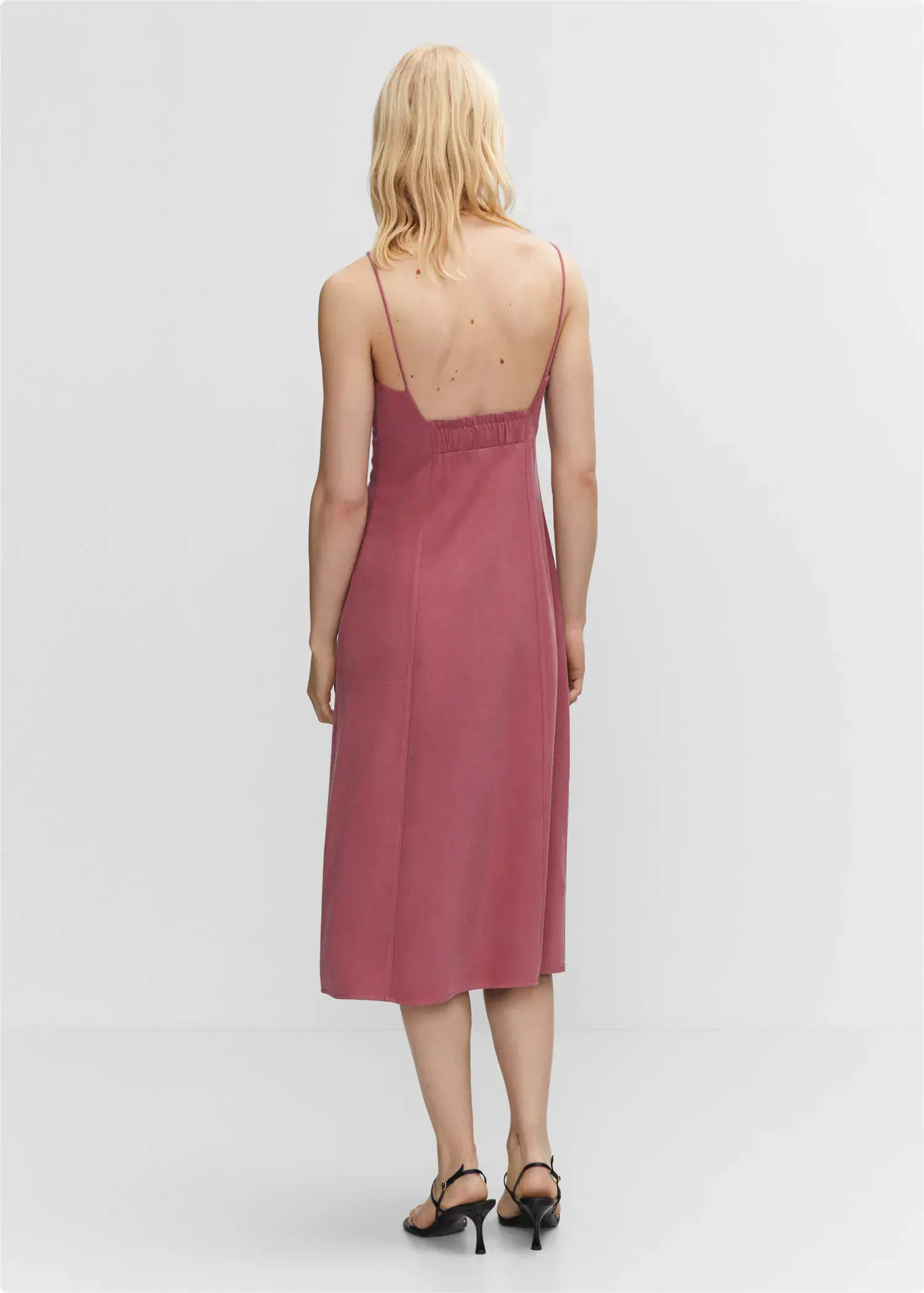 Mango Low-cut midi-dress. a person wearing a pink dress standing in a room. 