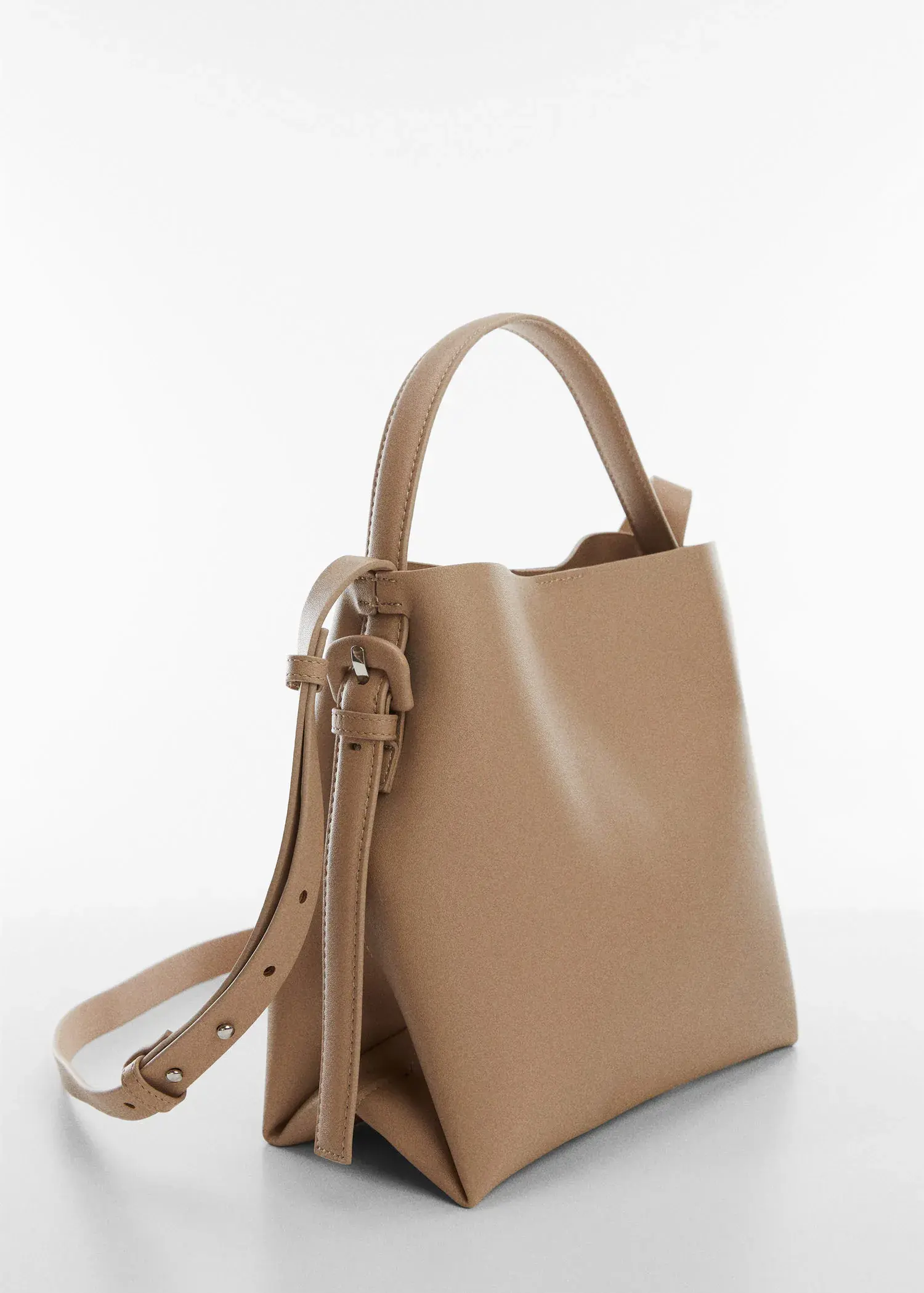 Mango Shopper bag with buckle. a tan bag is sitting on a table. 