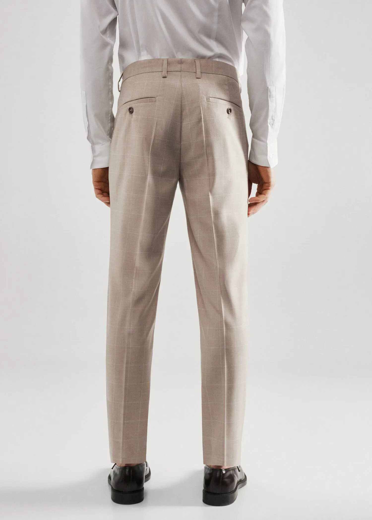 Mango Super slim-fit Tailored check pants. a man wearing a suit and tie standing in front of a white wall. 