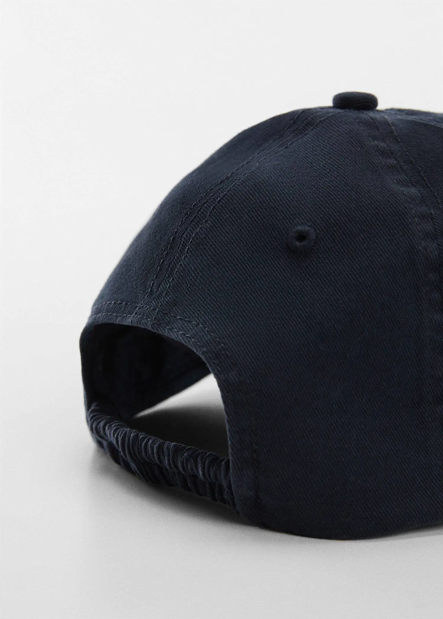 Mango Organic cotton cap. a close-up of a baseball cap on top of a white surface. 