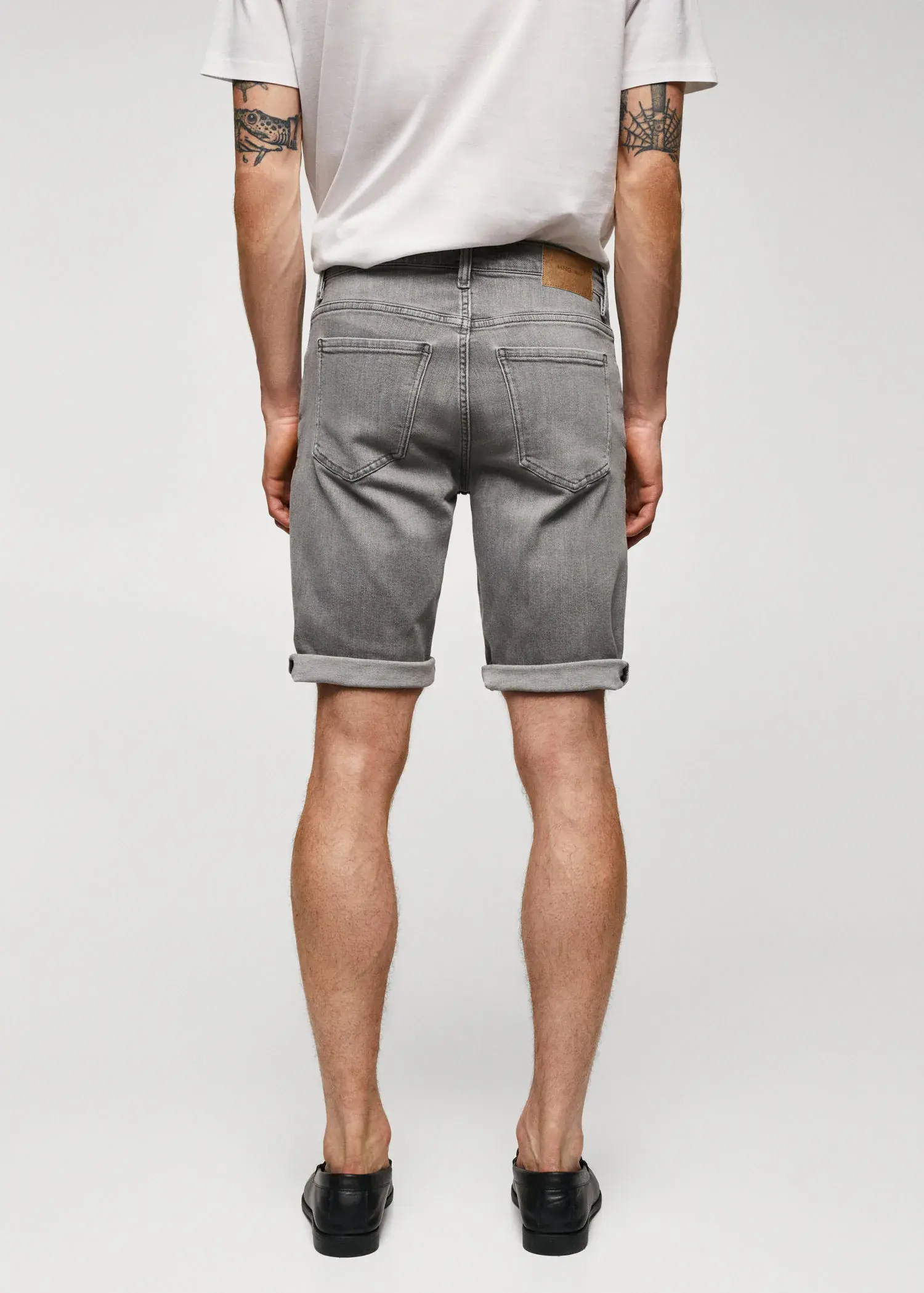 Mango Slim-fit denim bermuda shorts. a person wearing grey shorts and a white shirt. 