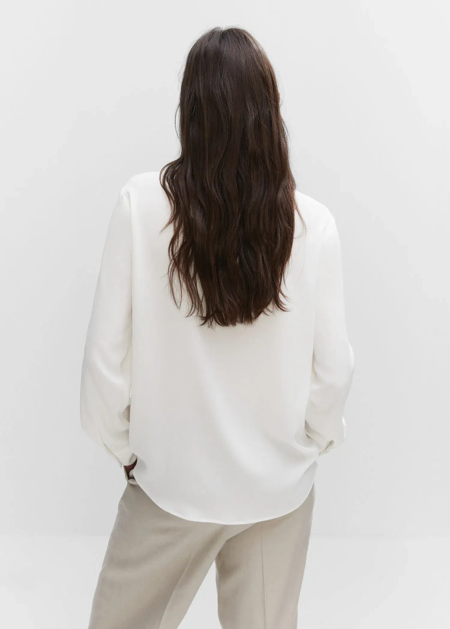 Mango Buttoned flowy shirt. a woman standing in front of a white wall. 