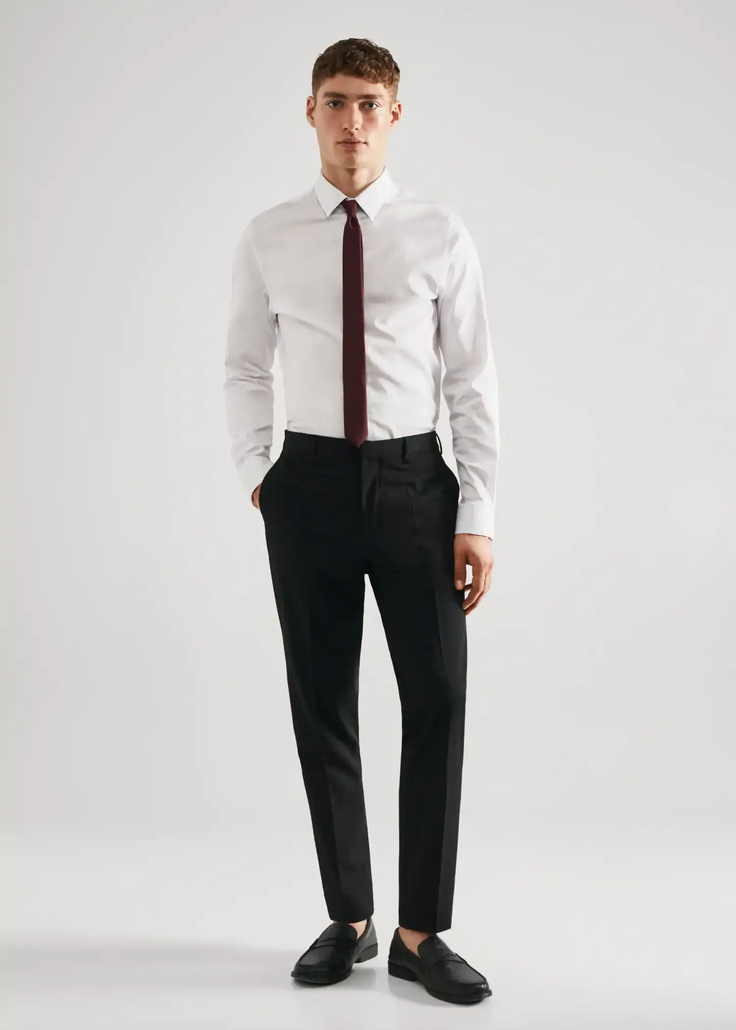 Mango Stretch fabric super slim-fit suit trousers. a man in a white shirt and black pants. 