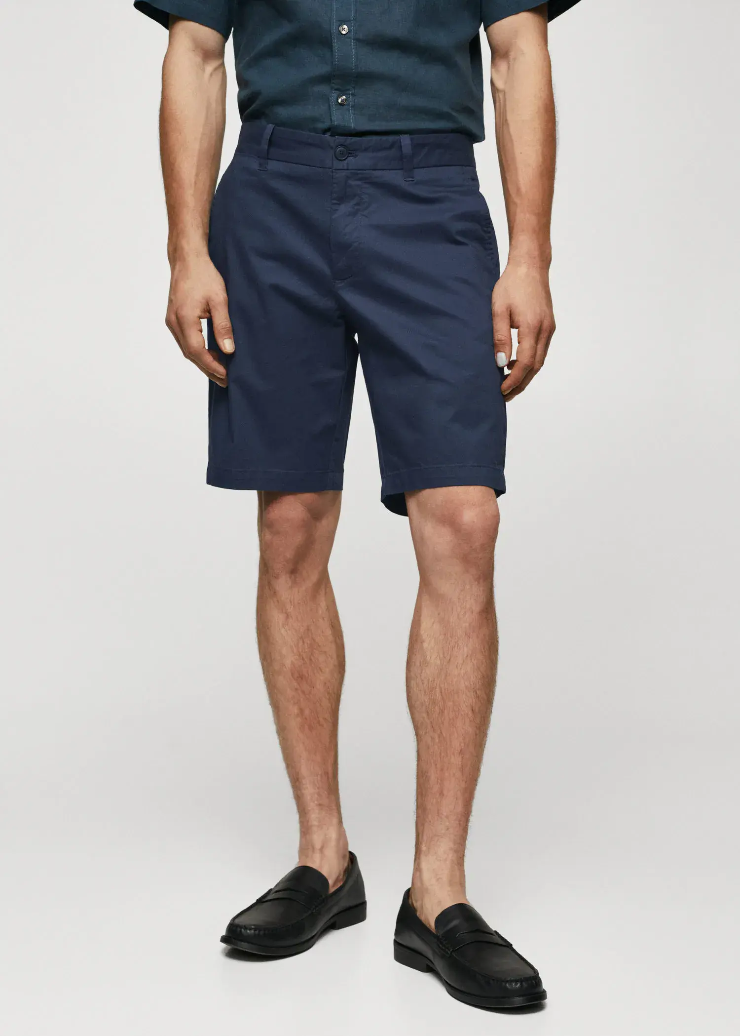 Mango Chino Bermuda shorts. a man wearing a pair of navy blue shorts. 