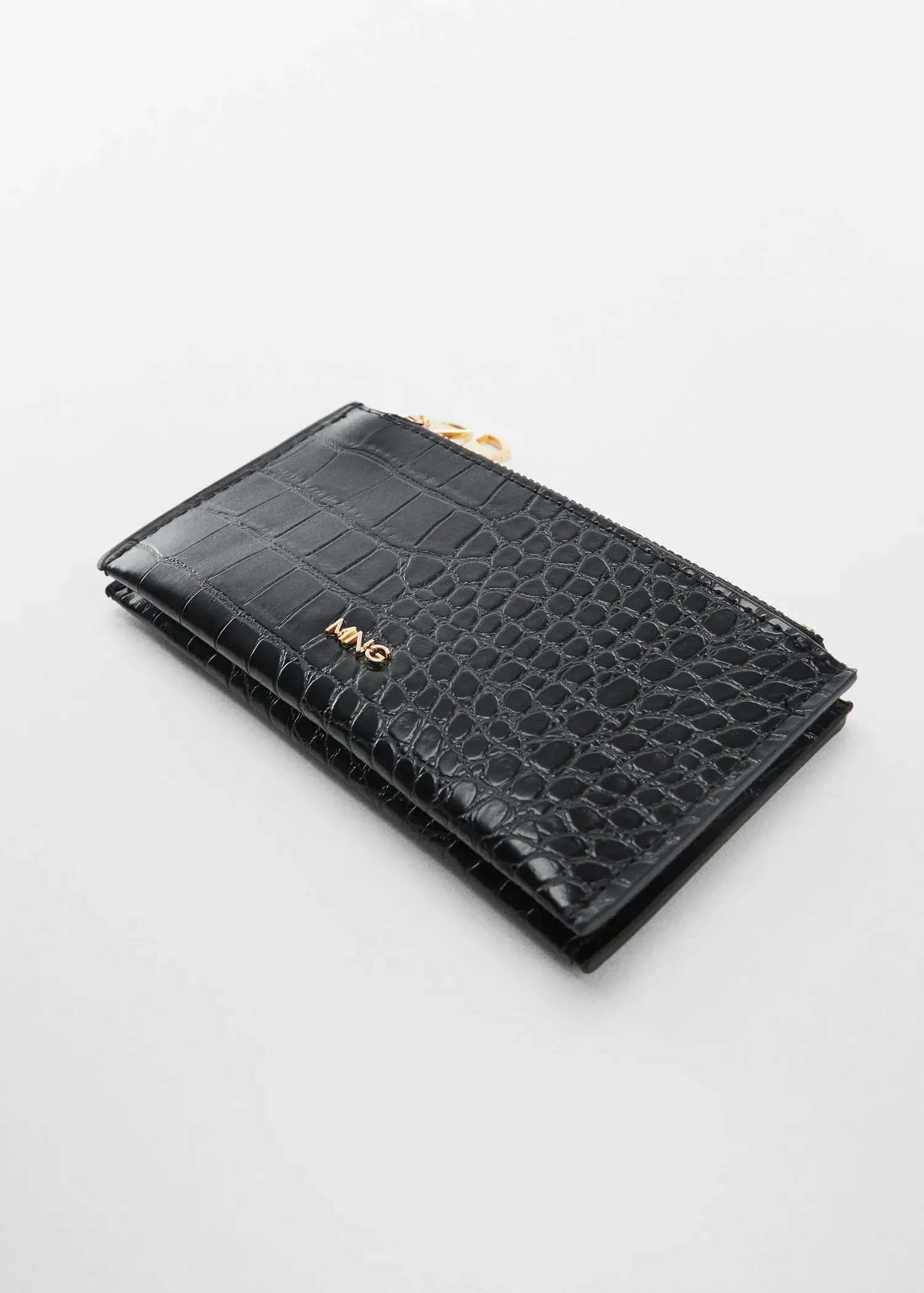 Mango Crocodile purse with logo. a black wallet is sitting on a table. 