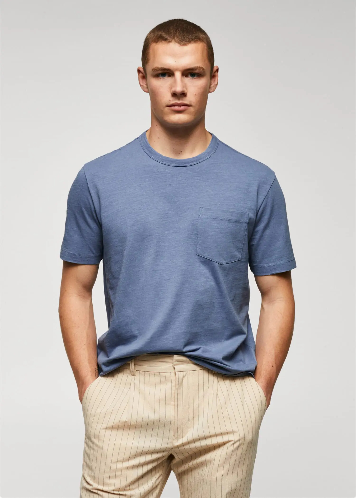 Mango 100% cotton t-shirt with pocket. a man in a blue t-shirt is posing for a picture. 