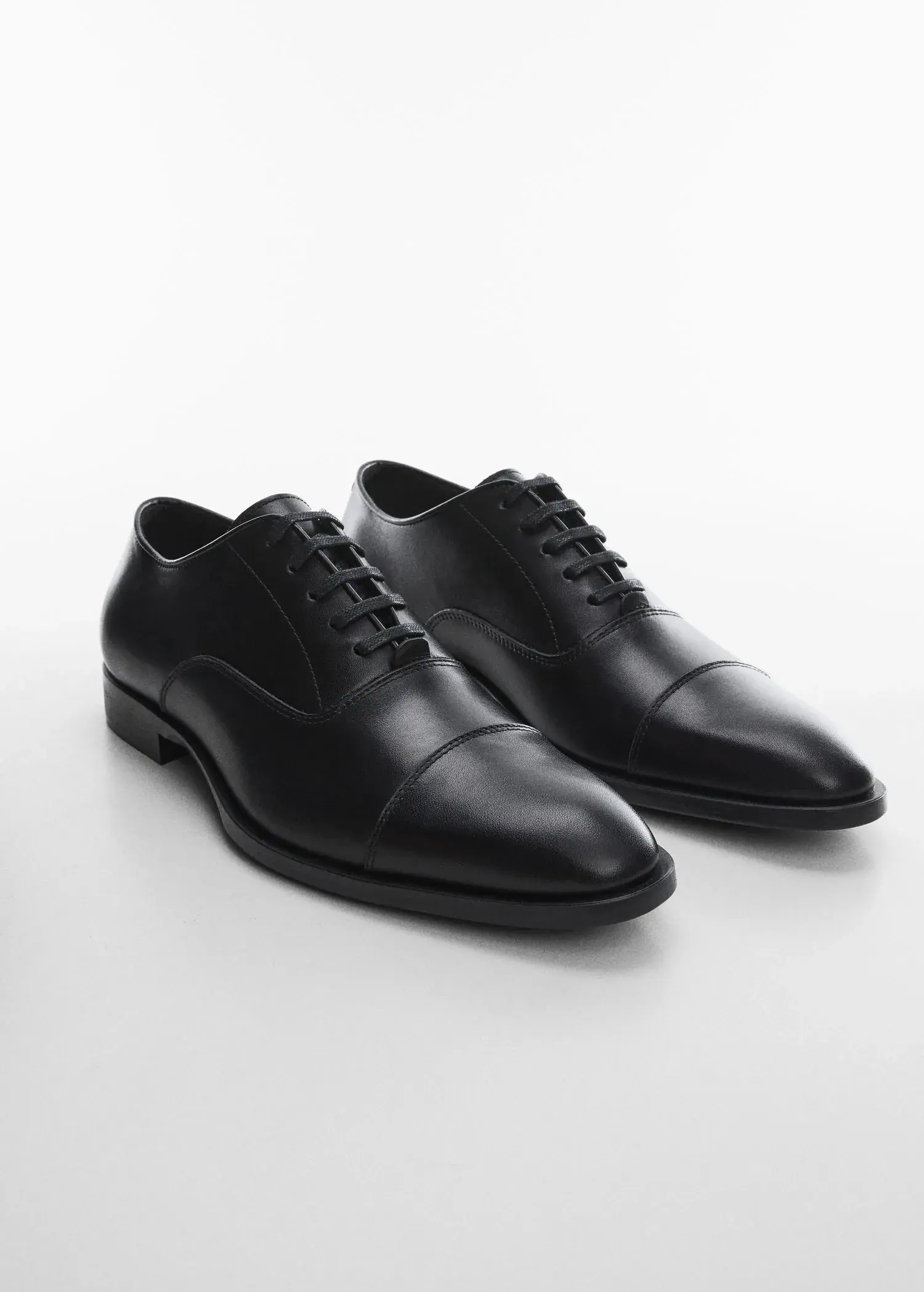 Mango Elongated leather suit shoes. a pair of black dress shoes sitting on top of a table. 
