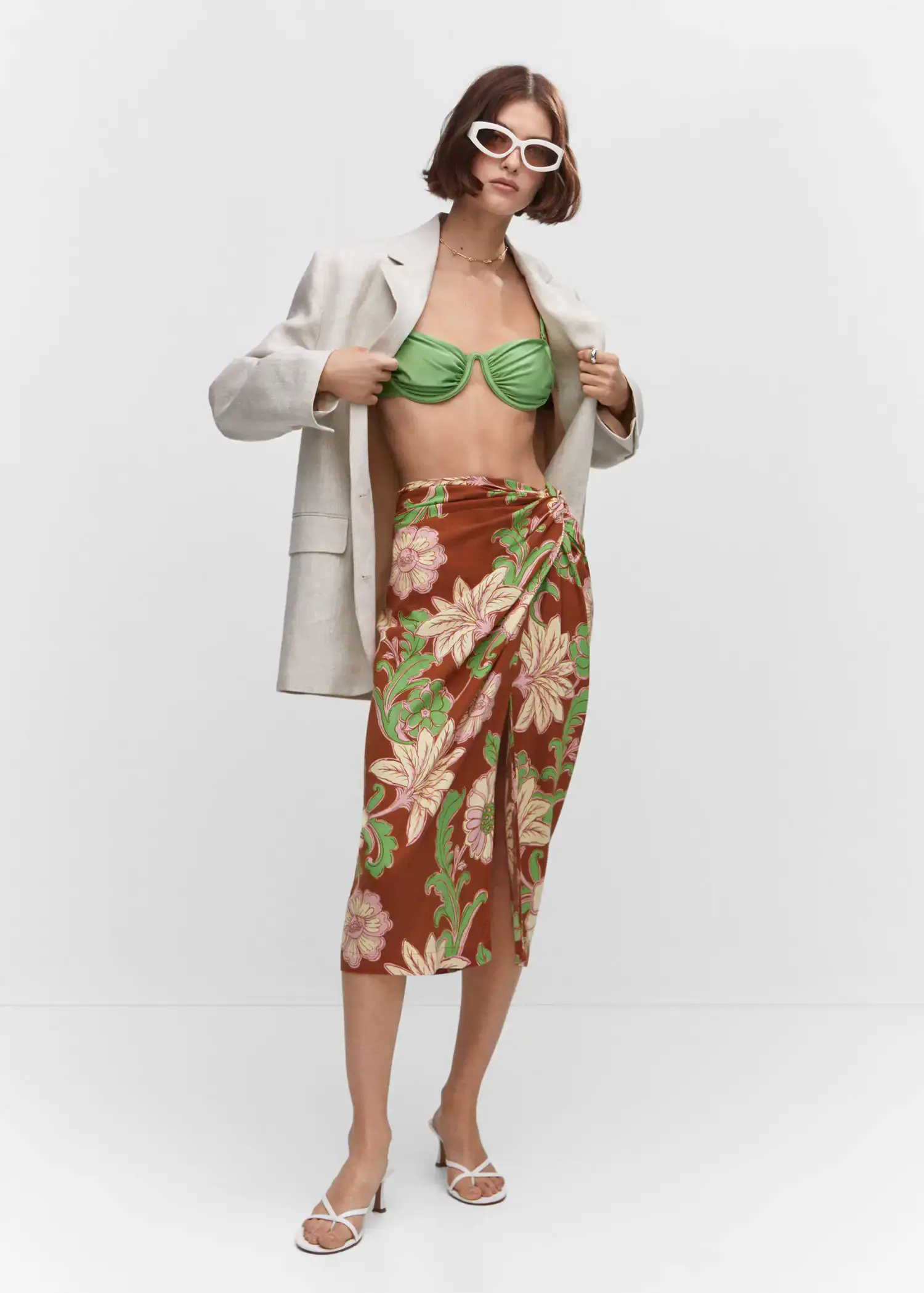 Mango Knot printed skirt. a woman wearing a green bra and a white jacket. 